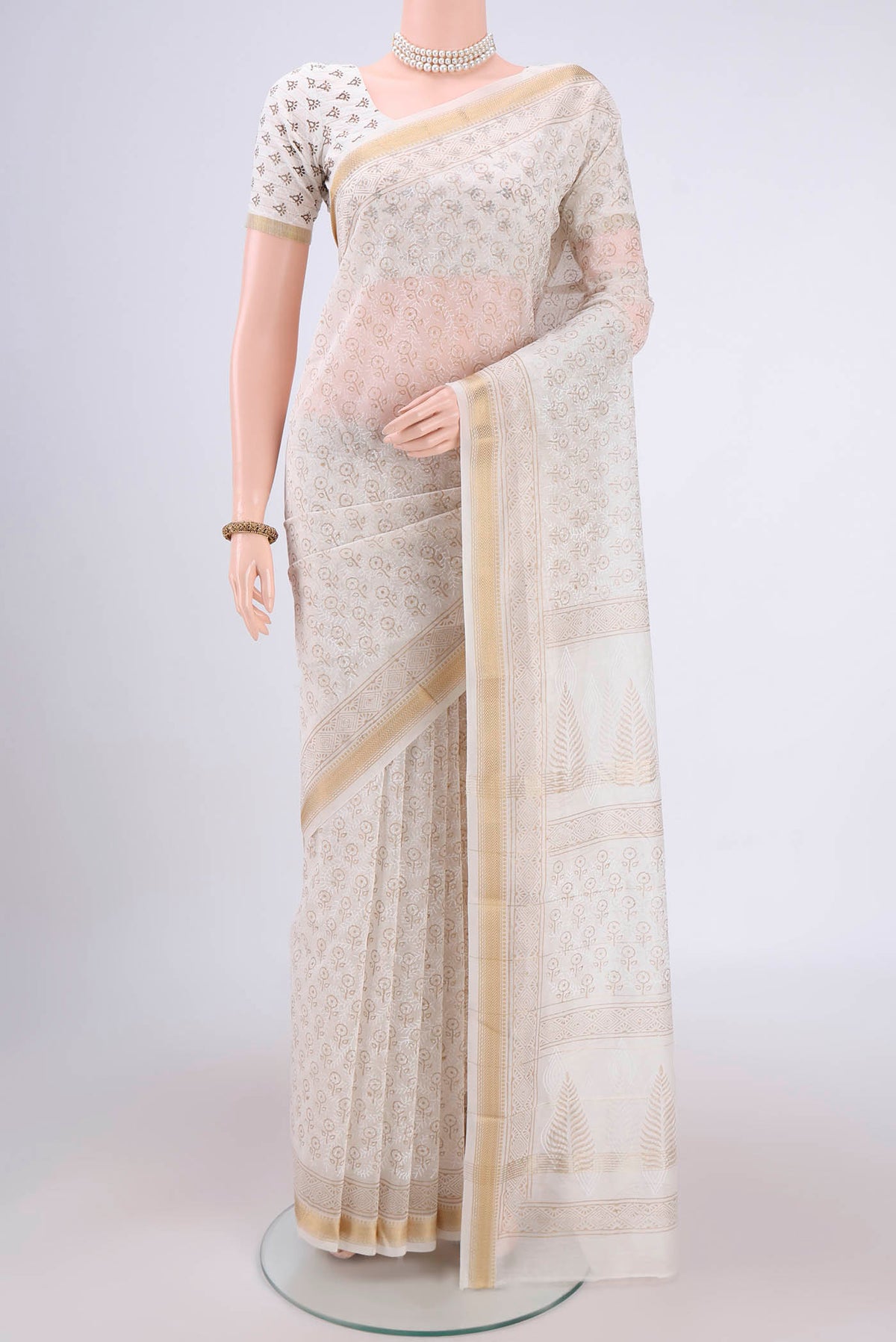 Off White Maheshwari Silk Cotton Saree with Batik Print on the body and Zari Border.  displayed on a mannequin