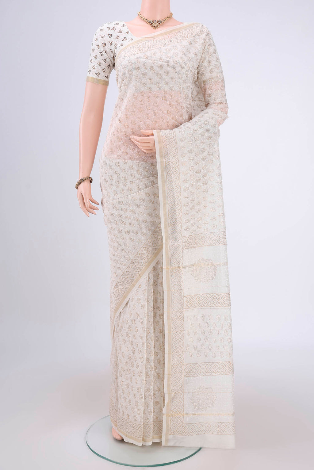 Off White Maheshwari Silk Cotton Saree with Batik Print on the body and Zari Border.  displayed on a mannequin