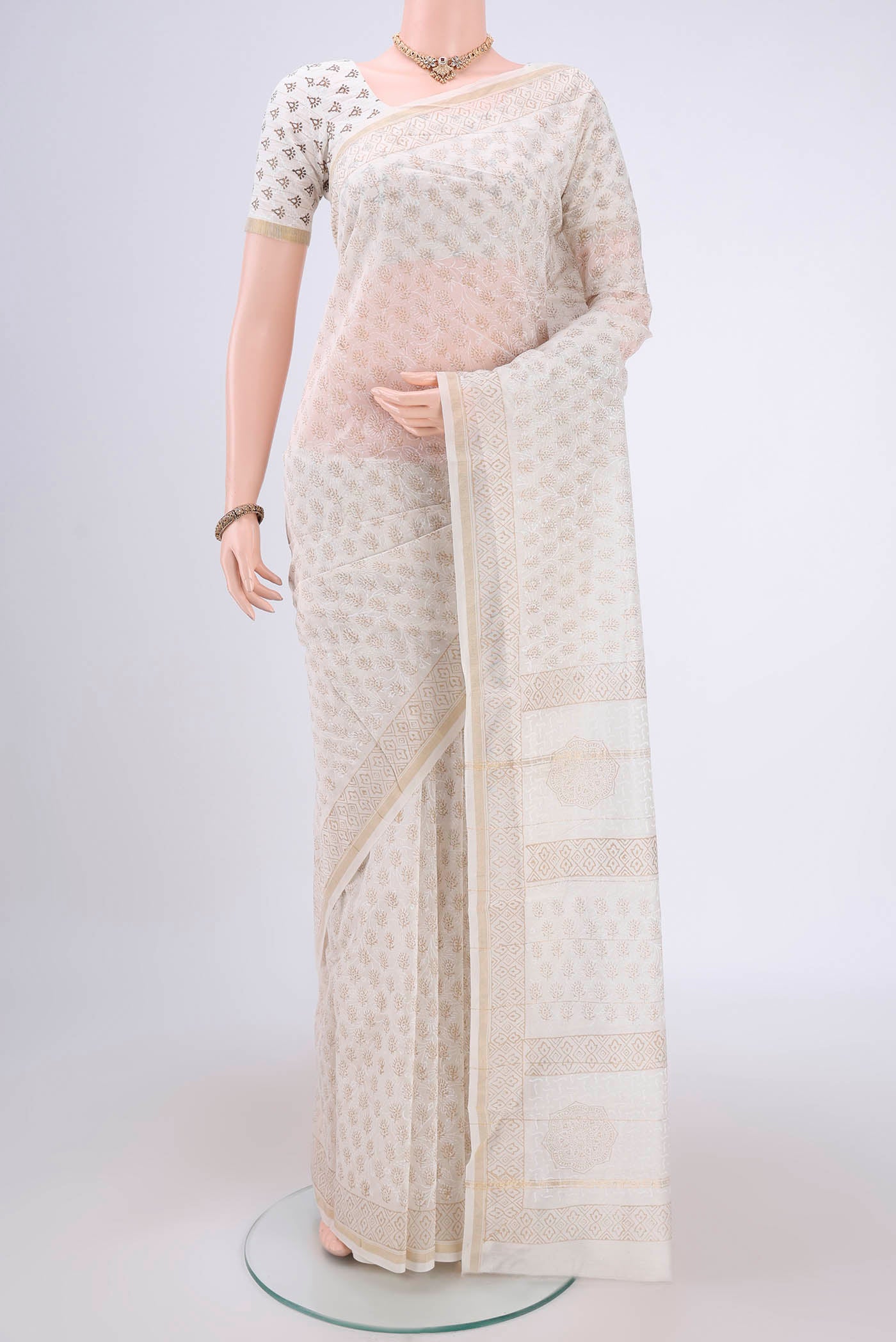 Off White Maheshwari Silk Cotton Saree with Batik Print on the body and Zari Border.  displayed on a mannequin