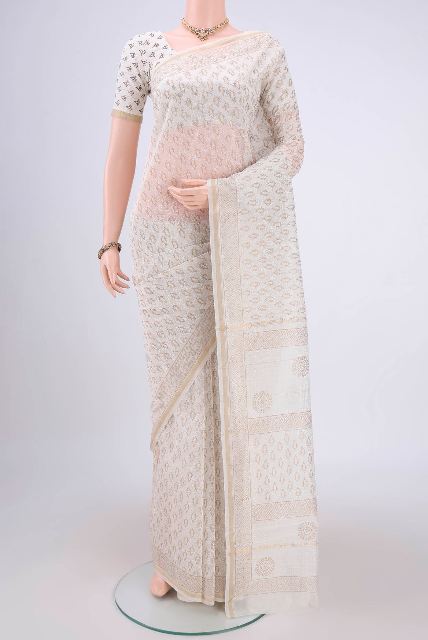Off White Maheshwari Silk Cotton Saree with Batik Print on the body and Zari Border.  displayed on a mannequin