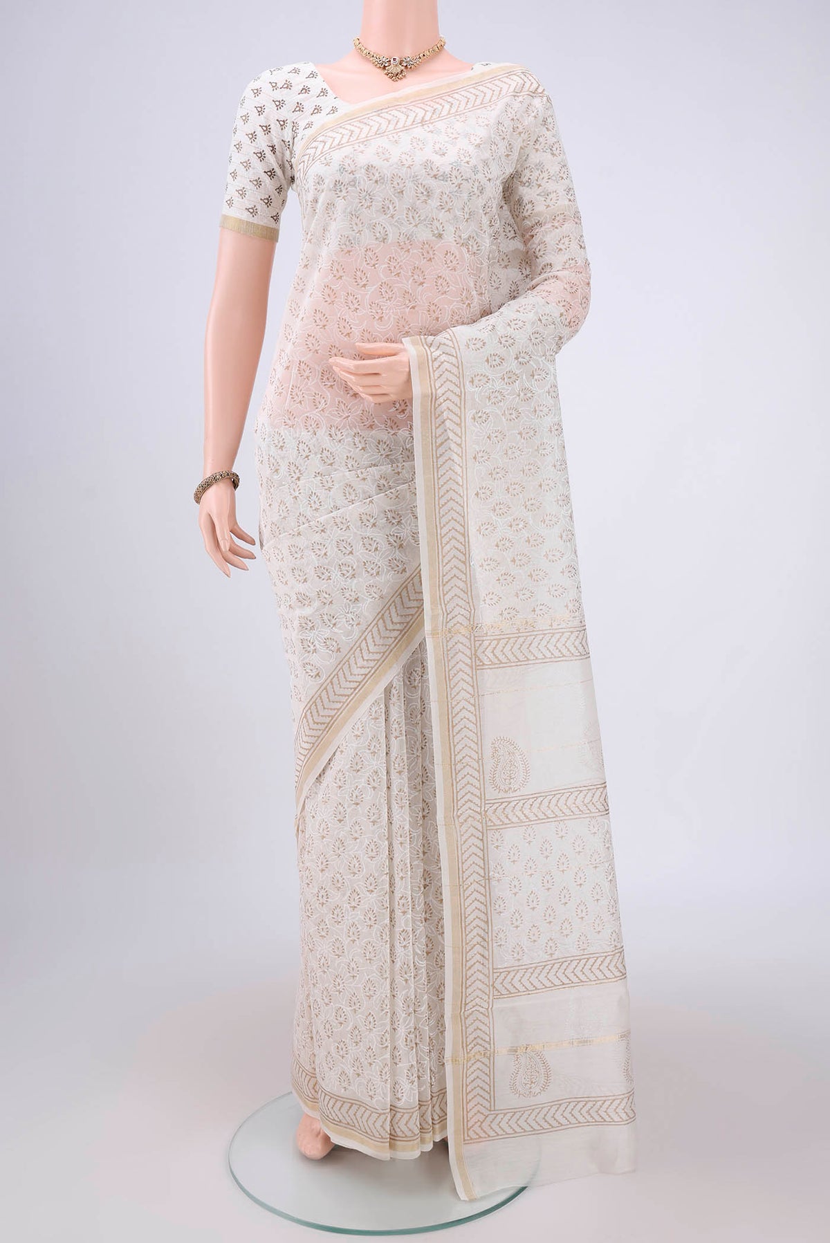 Off White Maheshwari Silk Cotton Saree with Batik Print on the body and Zari Border.  displayed on a mannequin