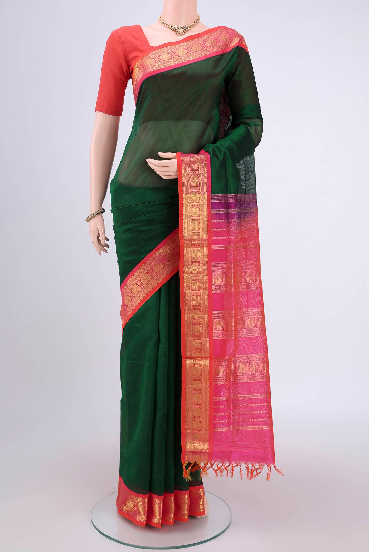Bottle Green Silk Cotton Saree with Plain Body and Zari Border.  displayed on a mannequin