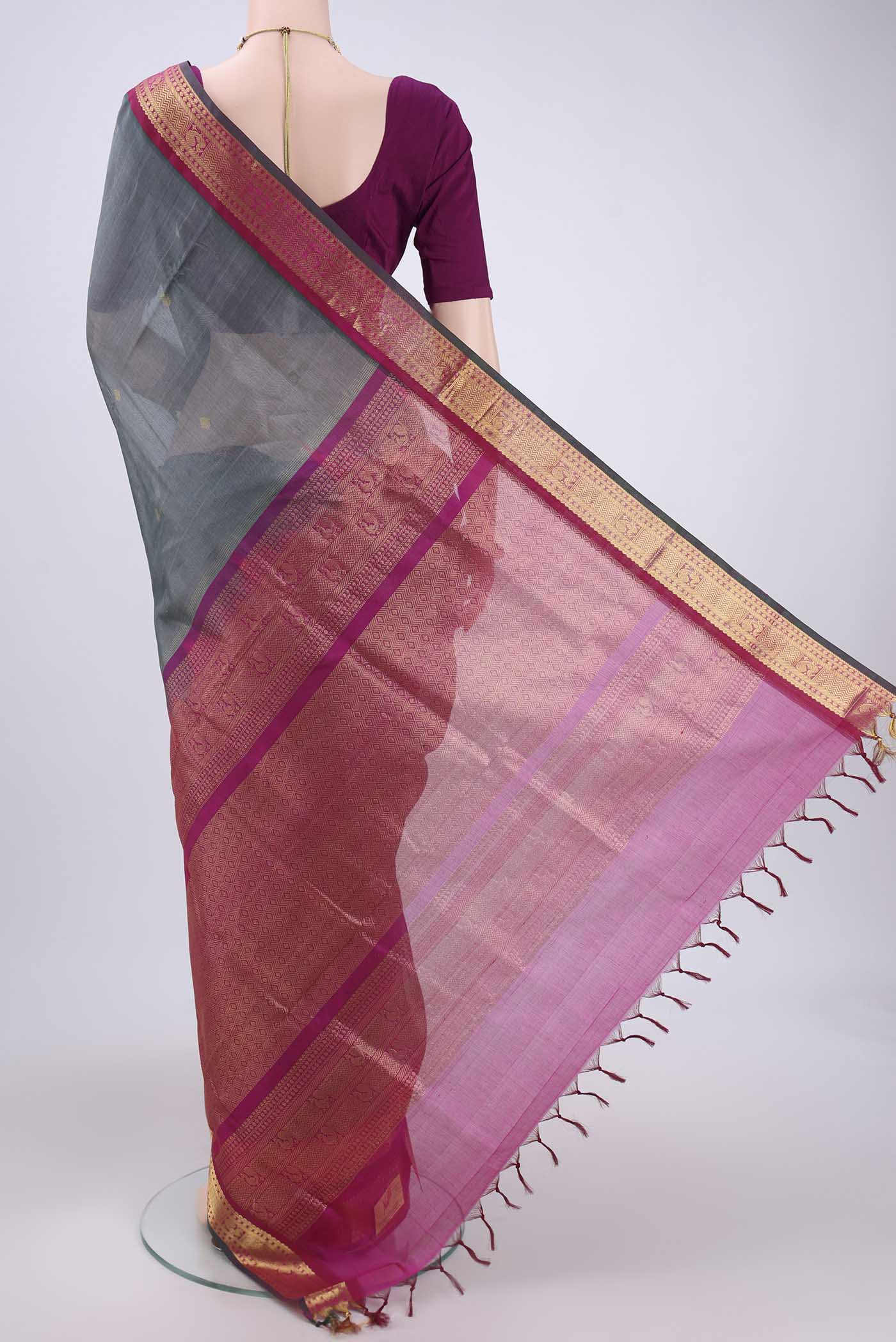 Flat view of Grey Silk Cotton Saree with Zari Butta on the body and Zari Border. 