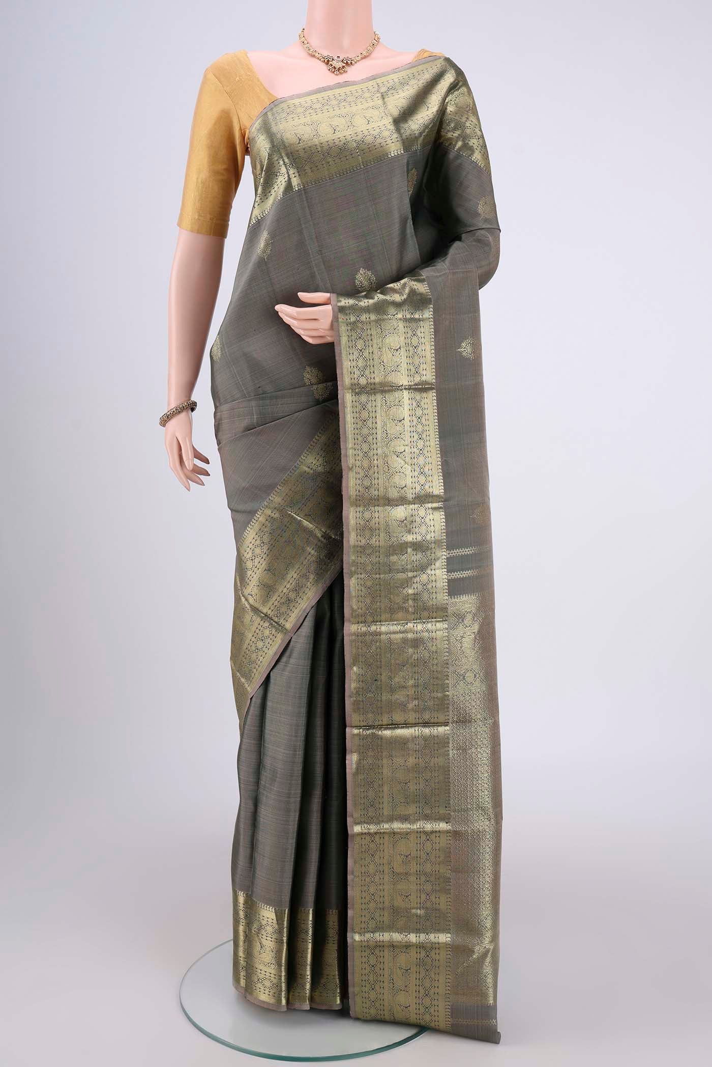 Grey Kanchipuram Silk Saree with Zari Butta on the body and Zari Border.  displayed on a mannequin