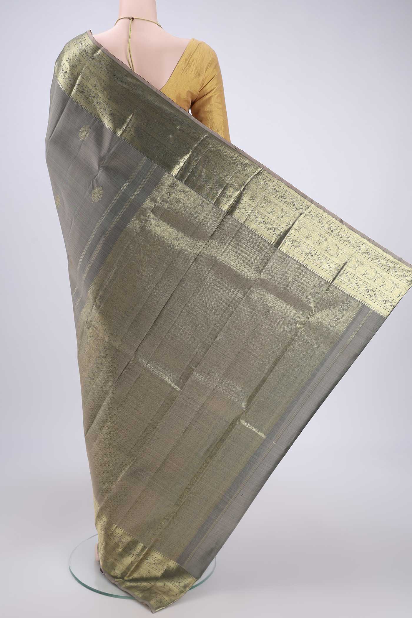 Flat view of Grey Kanchipuram Silk Saree with Zari Butta on the body and Zari Border. 