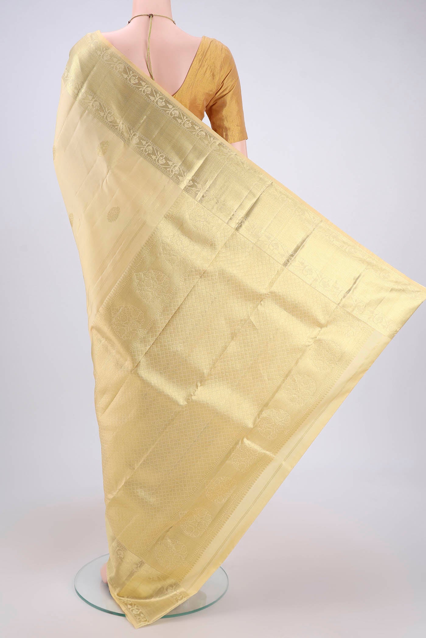 Flat view of Cream Kanchipuram Silk Saree with Zari Butta on the body and Zari Border. 