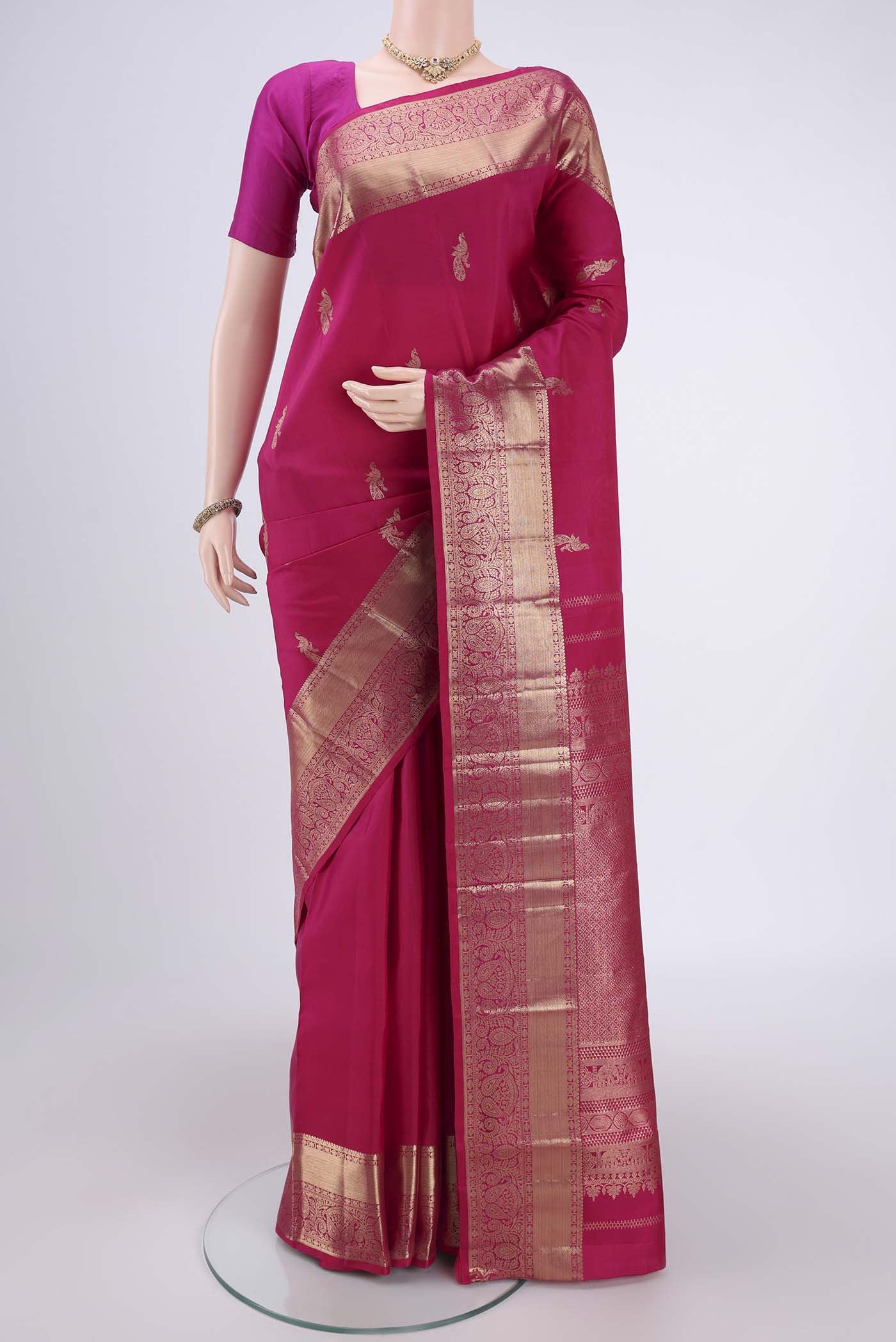 Rani Pink Kanchipuram Silk Saree with Checked design on the body and Zari Border.  displayed on a mannequin