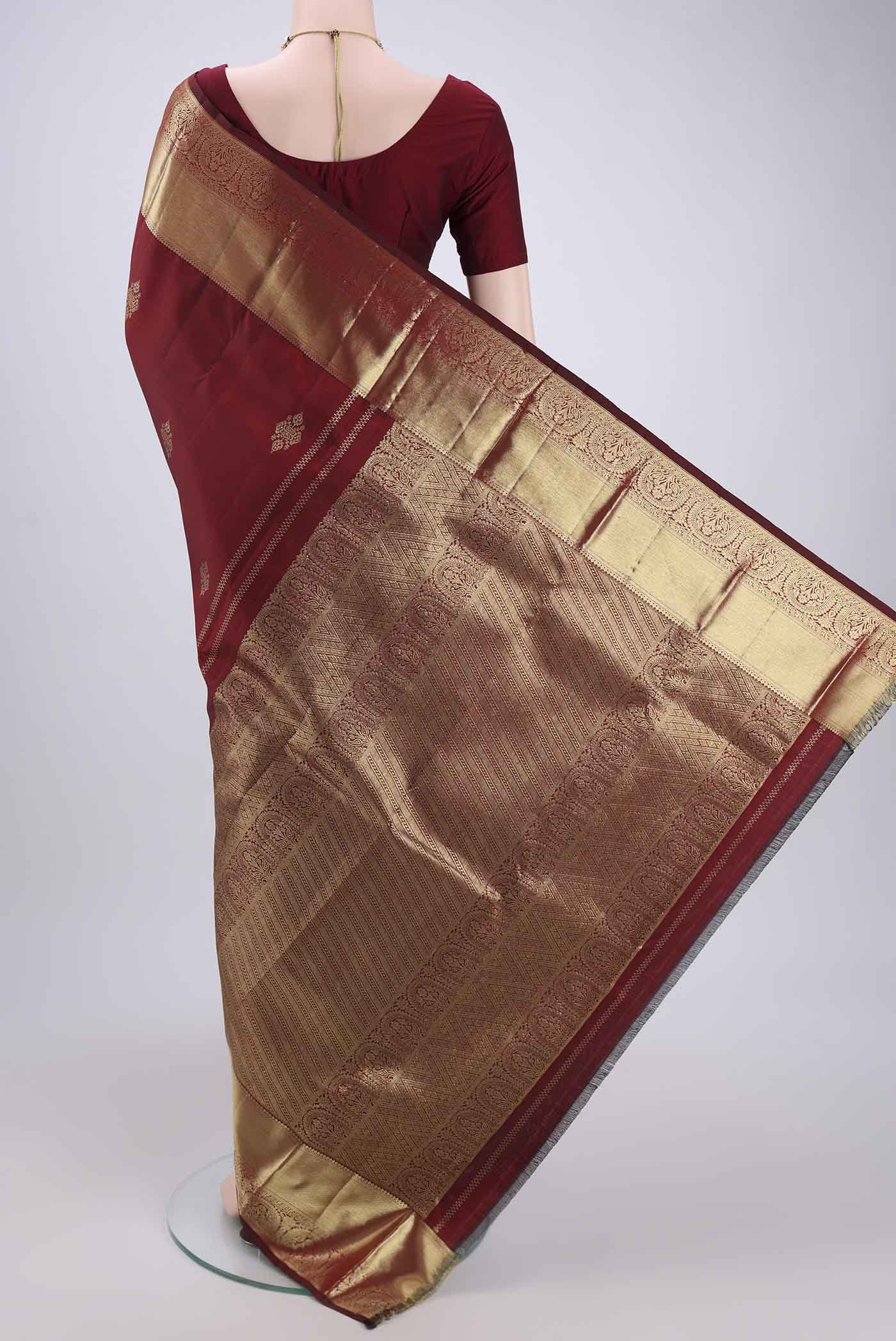 Flat view of Maroon Kanchipuram Silk Saree with Zari Butta on the body and Zari Border. 