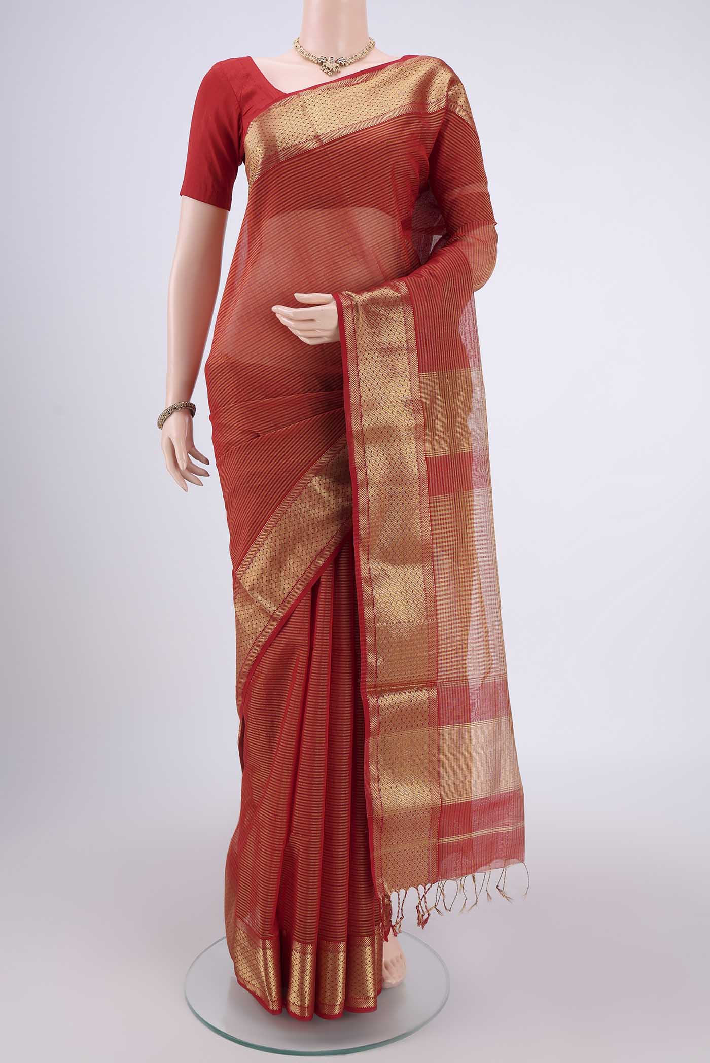 Orange Maheshwari Silk Cotton Saree with Zari And Thread Butta on the body and Zari Border.  displayed on a mannequin