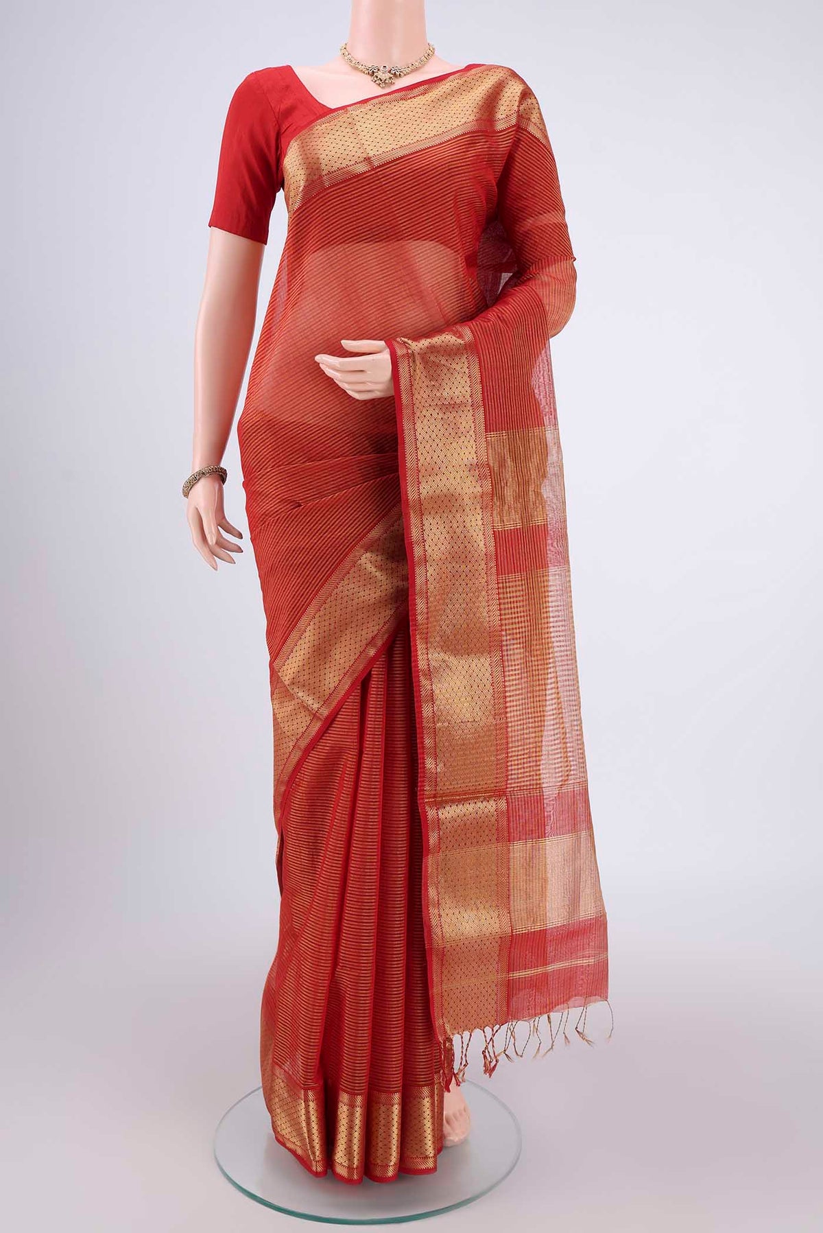 Orange Maheshwari Silk Cotton Saree with Zari And Thread Butta on the body and Zari Border.  displayed on a mannequin