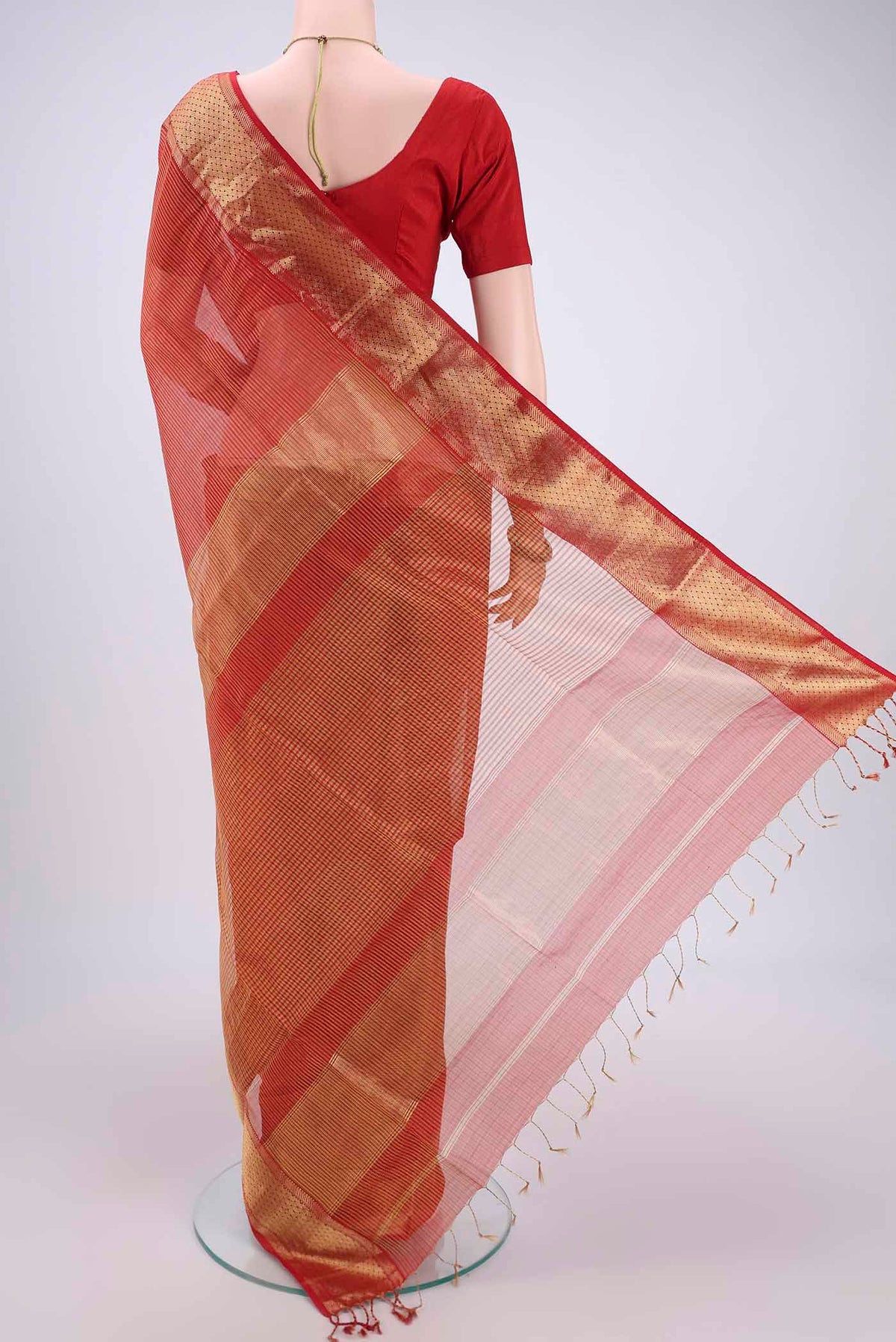 Flat view of Orange Maheshwari Silk Cotton Saree with Zari And Thread Butta on the body and Zari Border. 