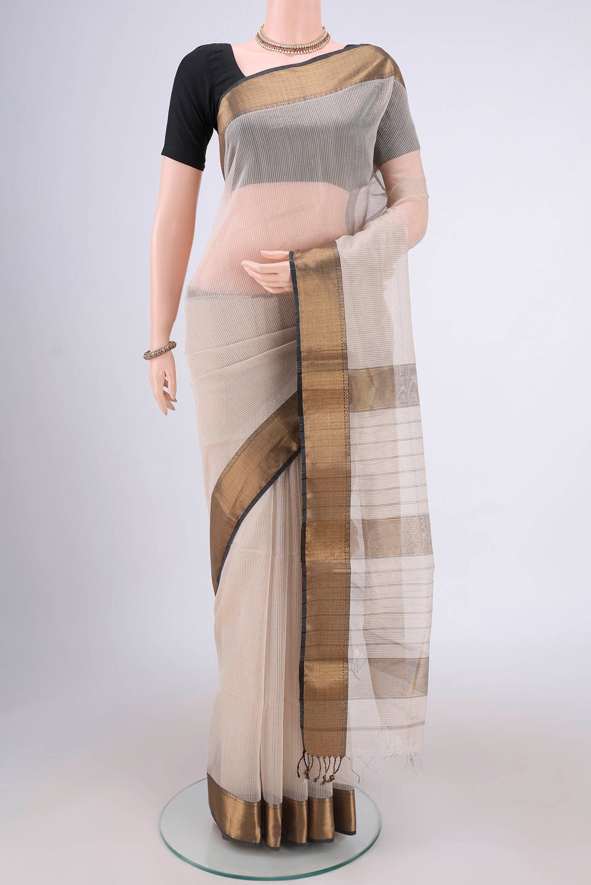 Beige Maheshwari Silk Cotton Saree with Checked design on the body and Zari Border.  displayed on a mannequin