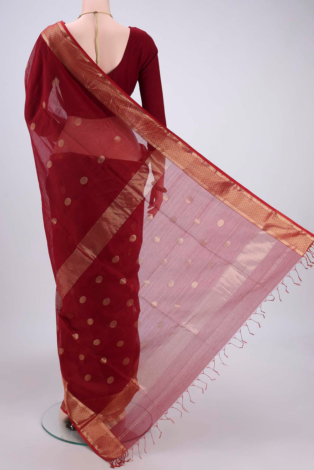 Flat view of Maroon Maheshwari Silk Cotton Saree with Polka Dots on the body and Zari Border. 