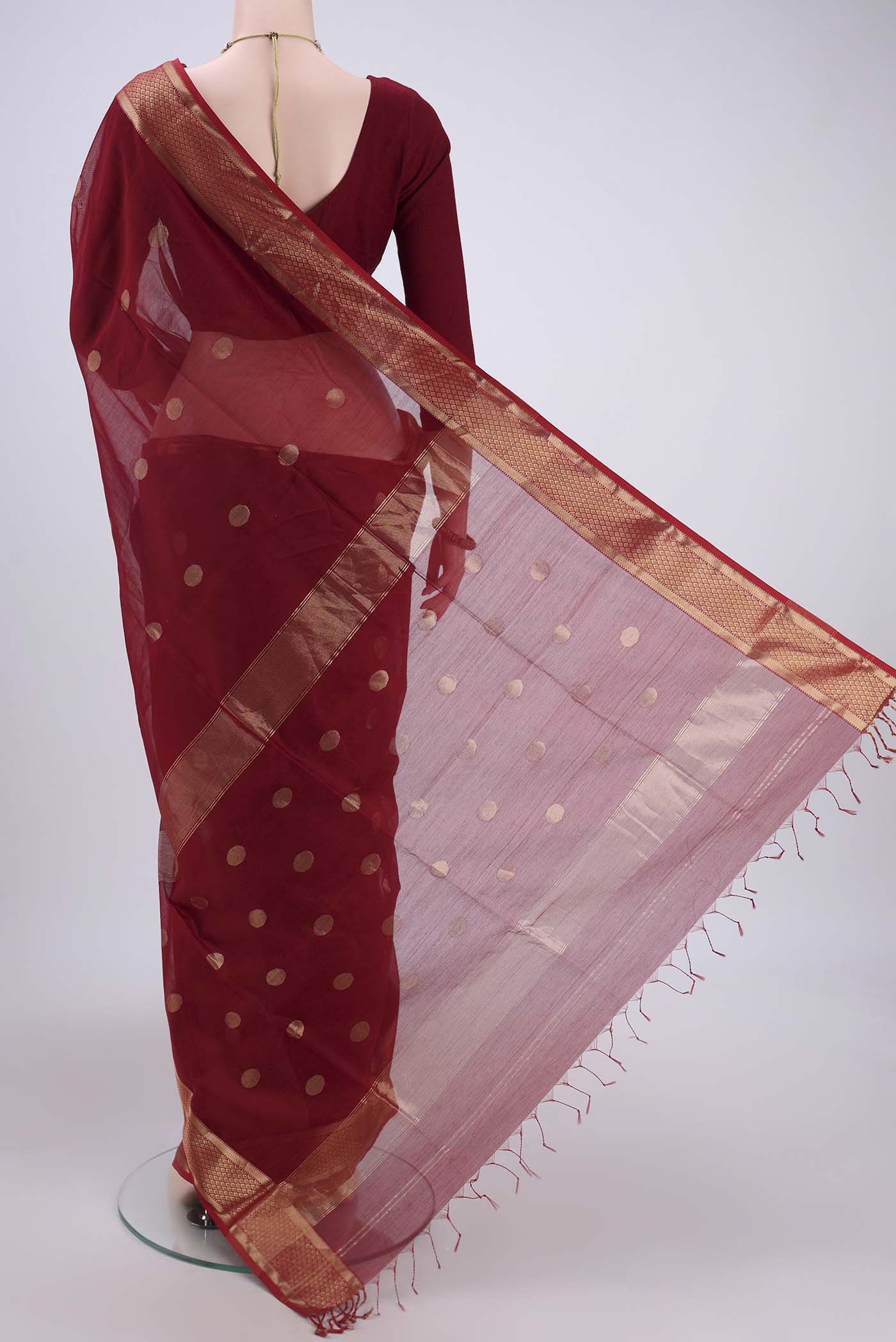 Flat view of Maroon Maheshwari Silk Cotton Saree with Polka Dots on the body and Zari Border. 