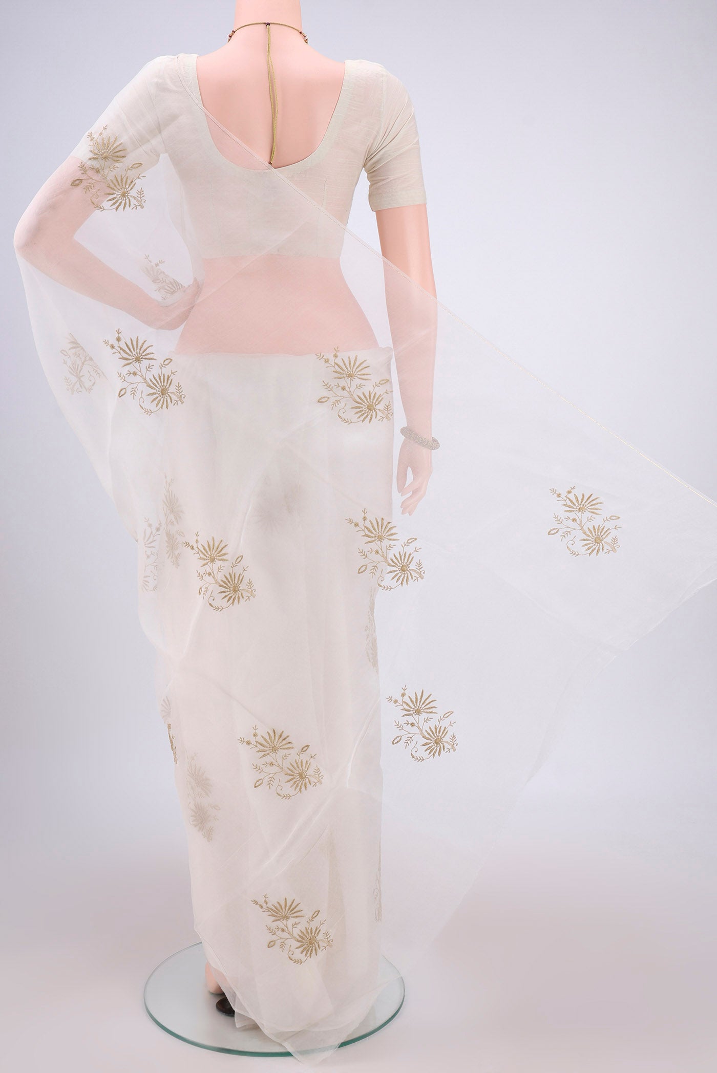 Flat view of White Organza Silk Saree with Embroidery on the body and Thin Zari Line. 