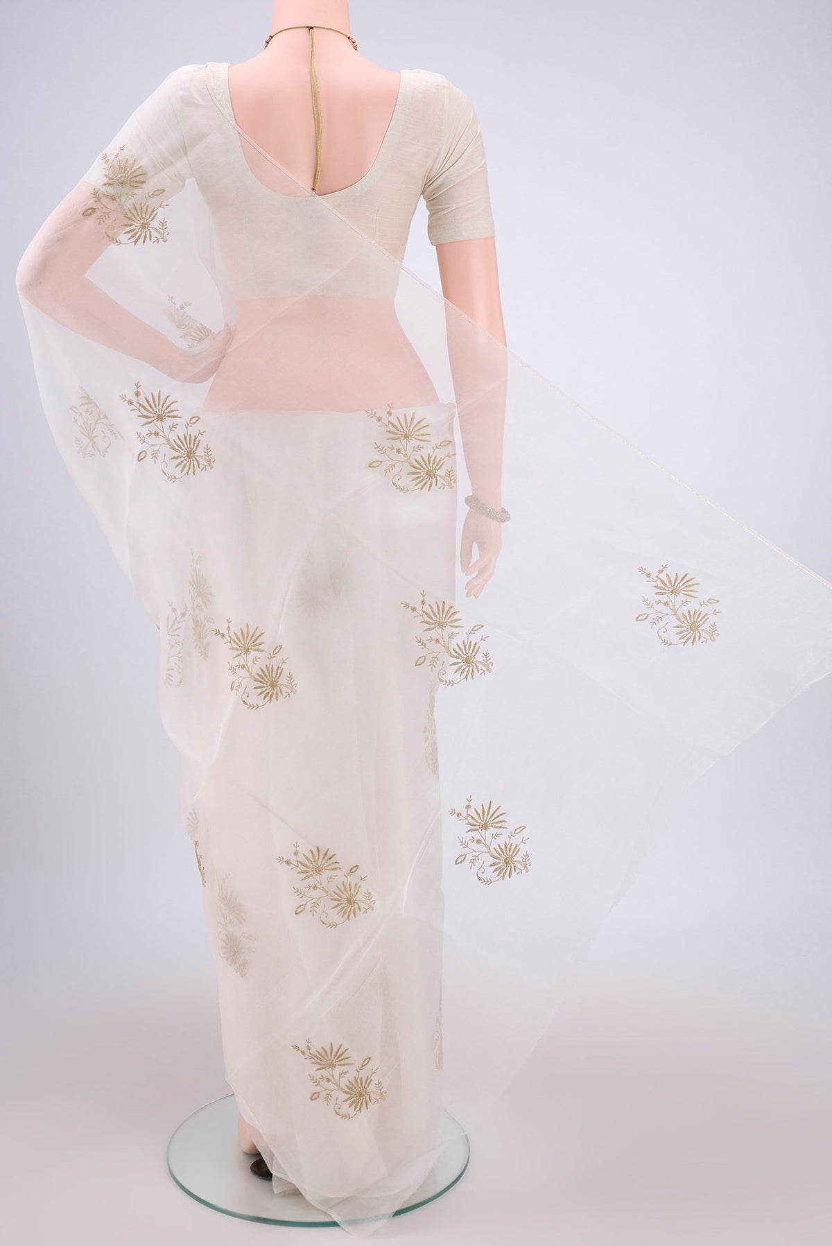 Flat view of White Organza Silk Saree with Embroidery on the body and Thin Zari Line. 