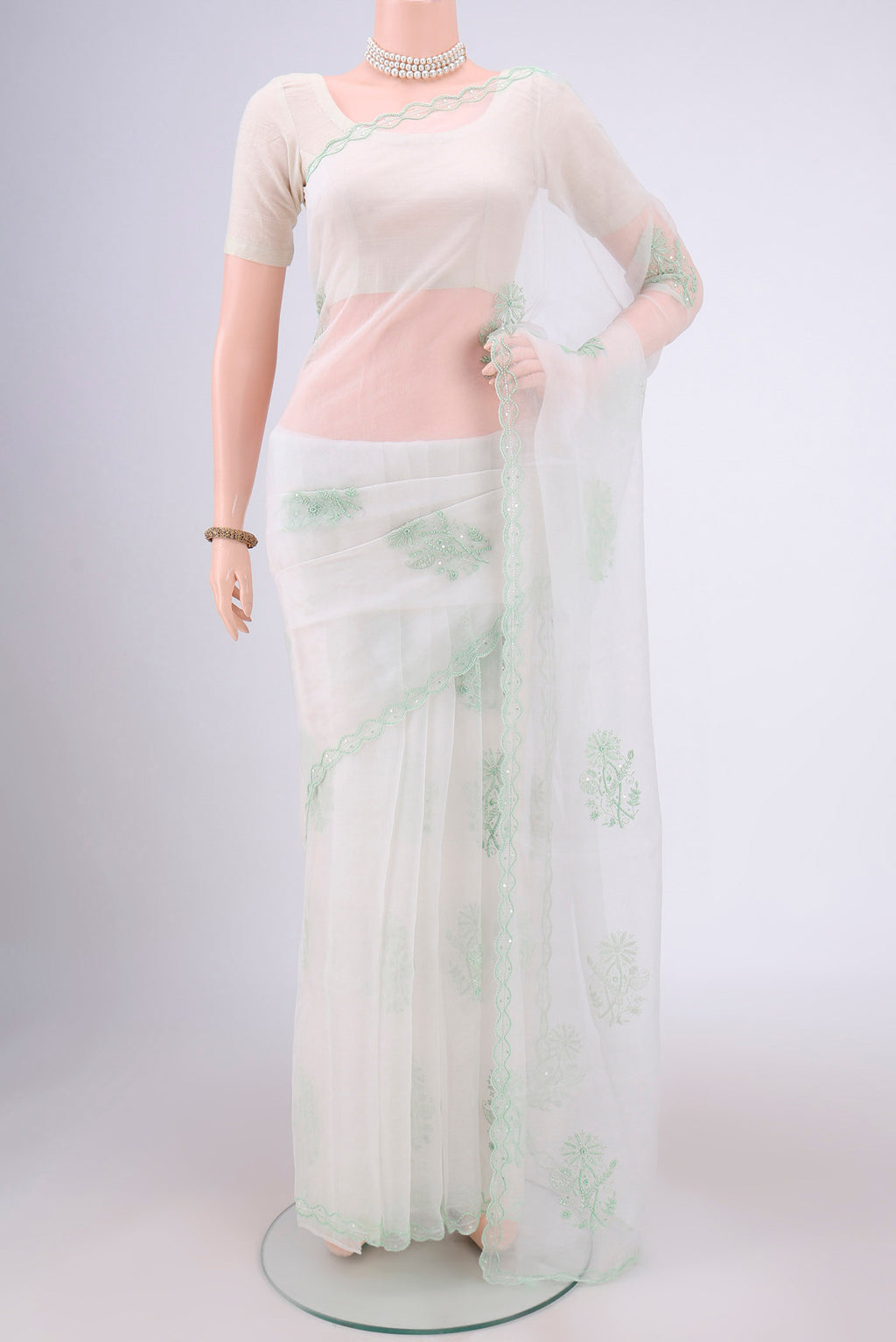 White Organza Silk Saree with Embroidery on the body and Thin Zari Line.  displayed on a mannequin