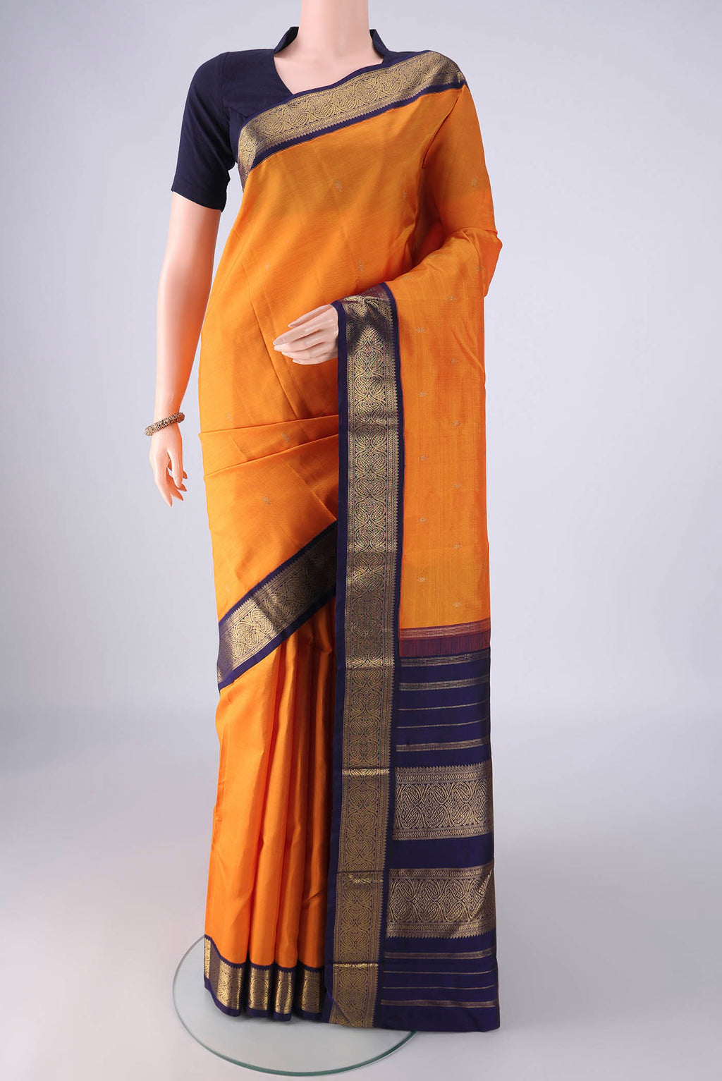 Pure Silk Pure Zari Brick Orange Kanjivaram Saree with Zari Butta on the body and Zari Border.  displayed on a mannequin