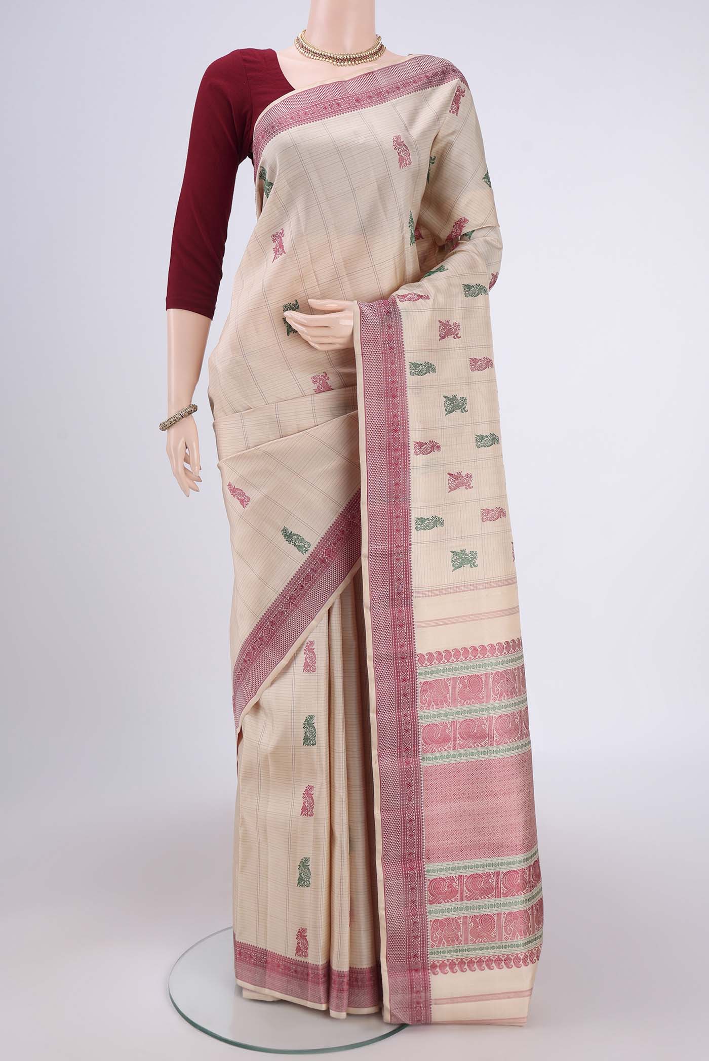 Beige Kanchipuram Saree with Thread Butta on the body and Thread Border.  displayed on a mannequin