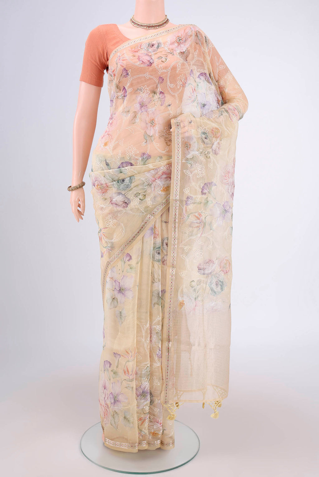 Beige Organza Silk Saree with Embroidery on the body and Zari Border.  displayed on a mannequin