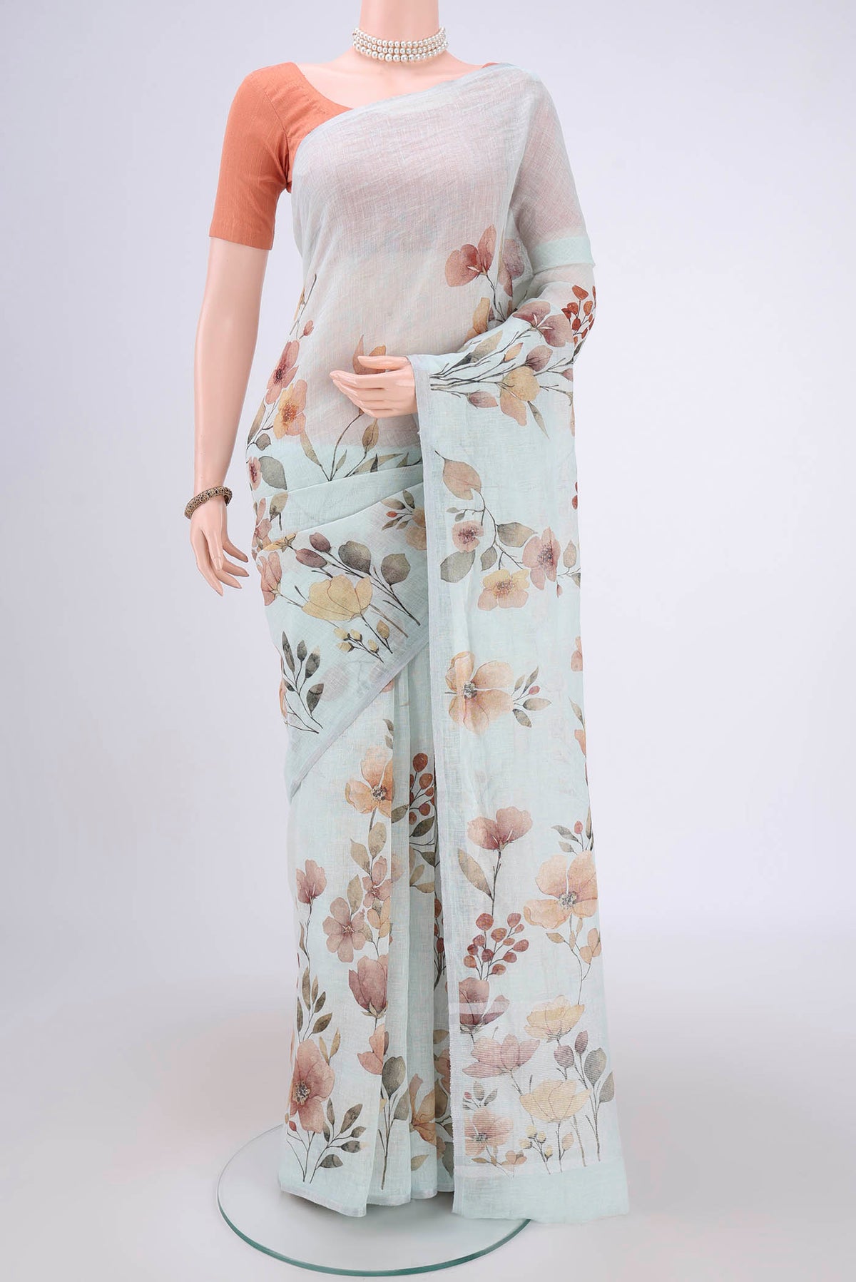 Sky Blue Linen Saree with Floral Print on the body and Zari Border.  displayed on a mannequin