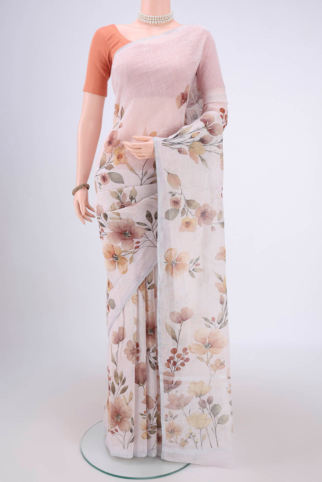 Off White Linen Saree with Floral Print on the body and Zari Border.  displayed on a mannequin