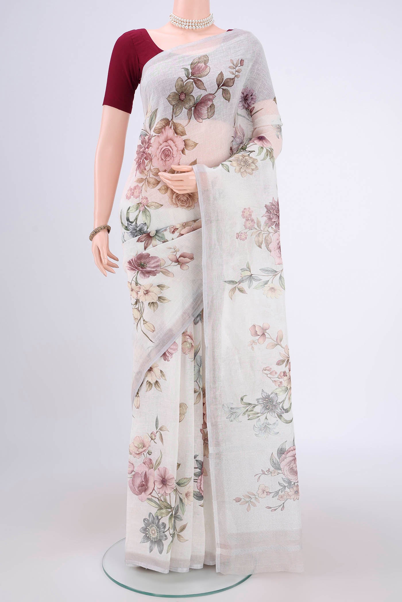 Off White Linen Saree with Floral Print on the body and Zari Border.  displayed on a mannequin