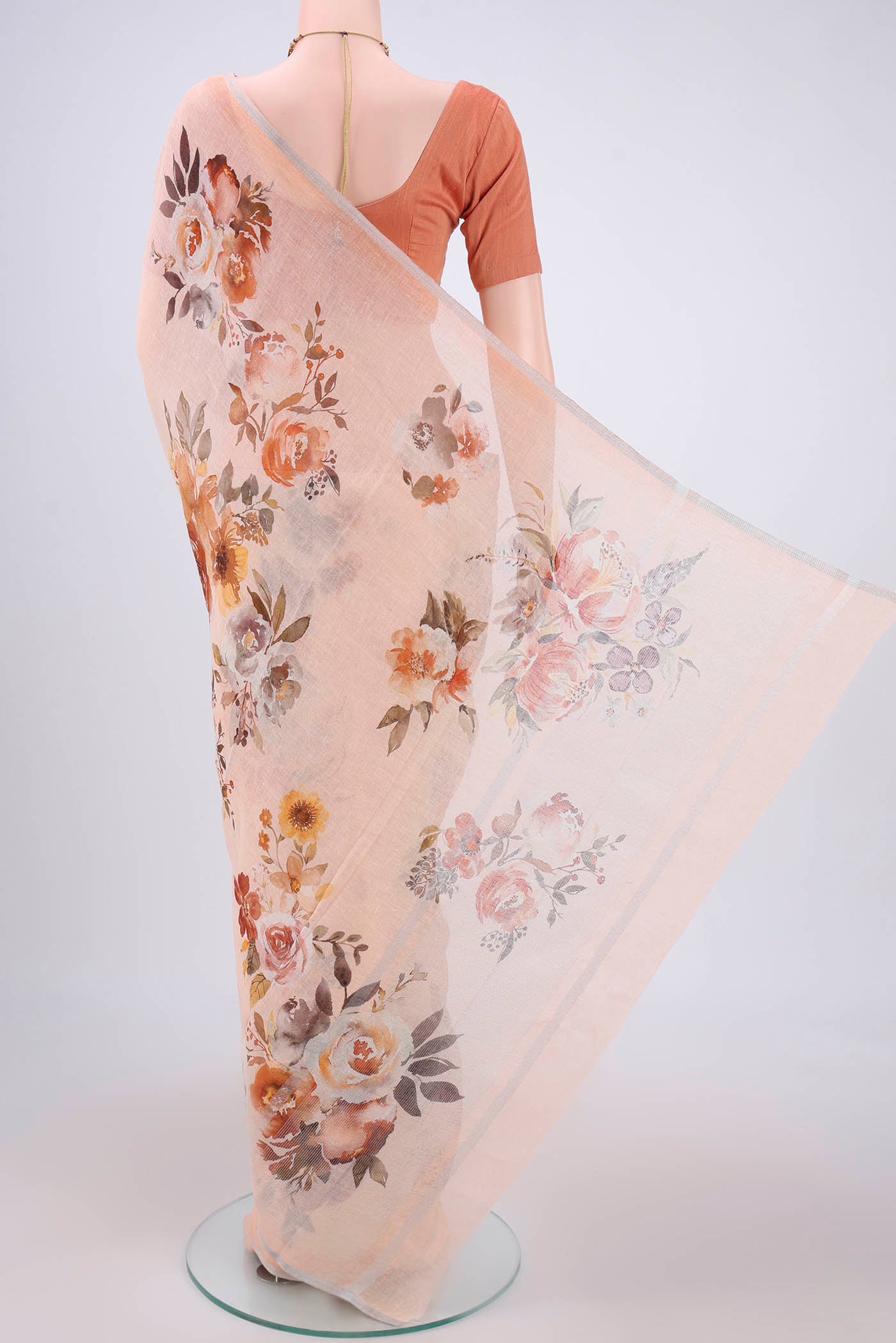 Flat view of Peach Linen Saree with Floral Print on the body and Zari Border. 