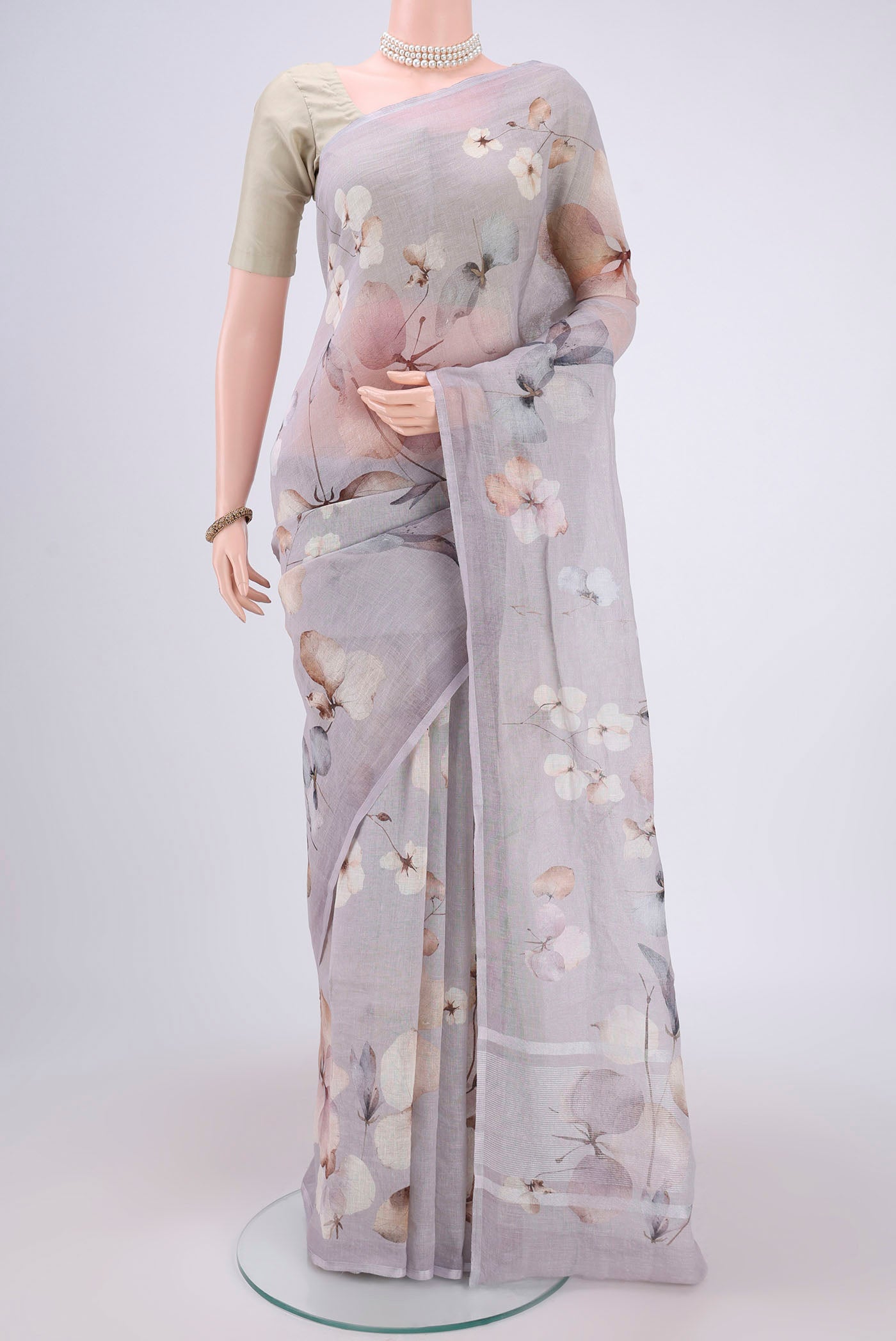 Grey Linen Saree with Floral Print on the body and Zari Border.  displayed on a mannequin