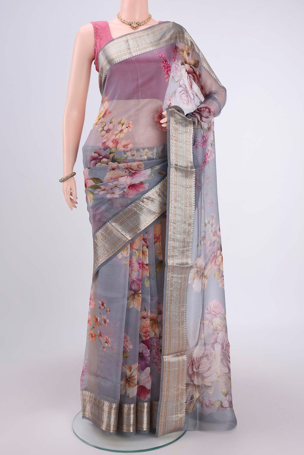Blue Grey Organza Silk Saree with Printed design on the body and Zari Border.  displayed on a mannequin
