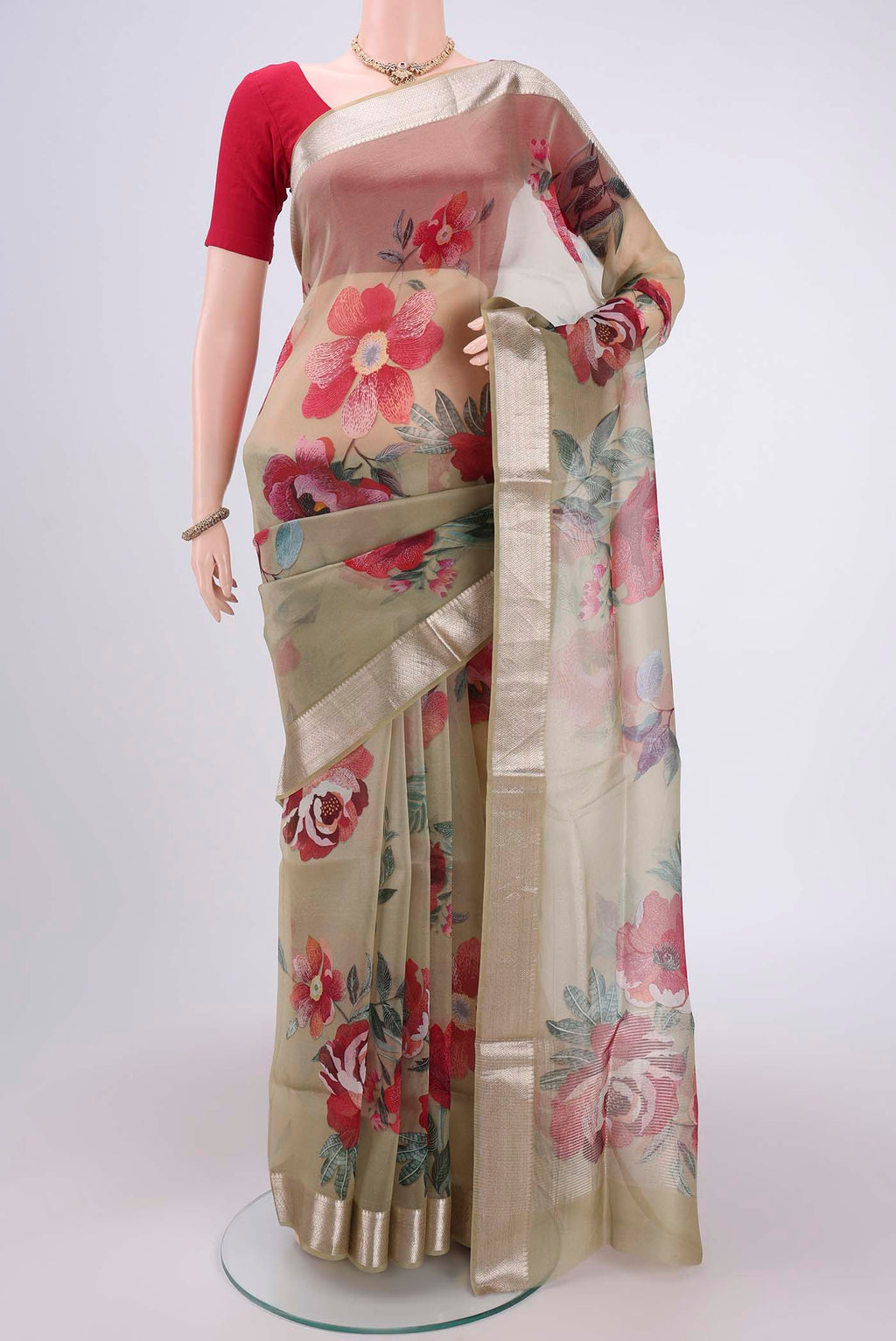 Sage Green Organza Silk Saree with Printed design on the body and Zari Border.  displayed on a mannequin