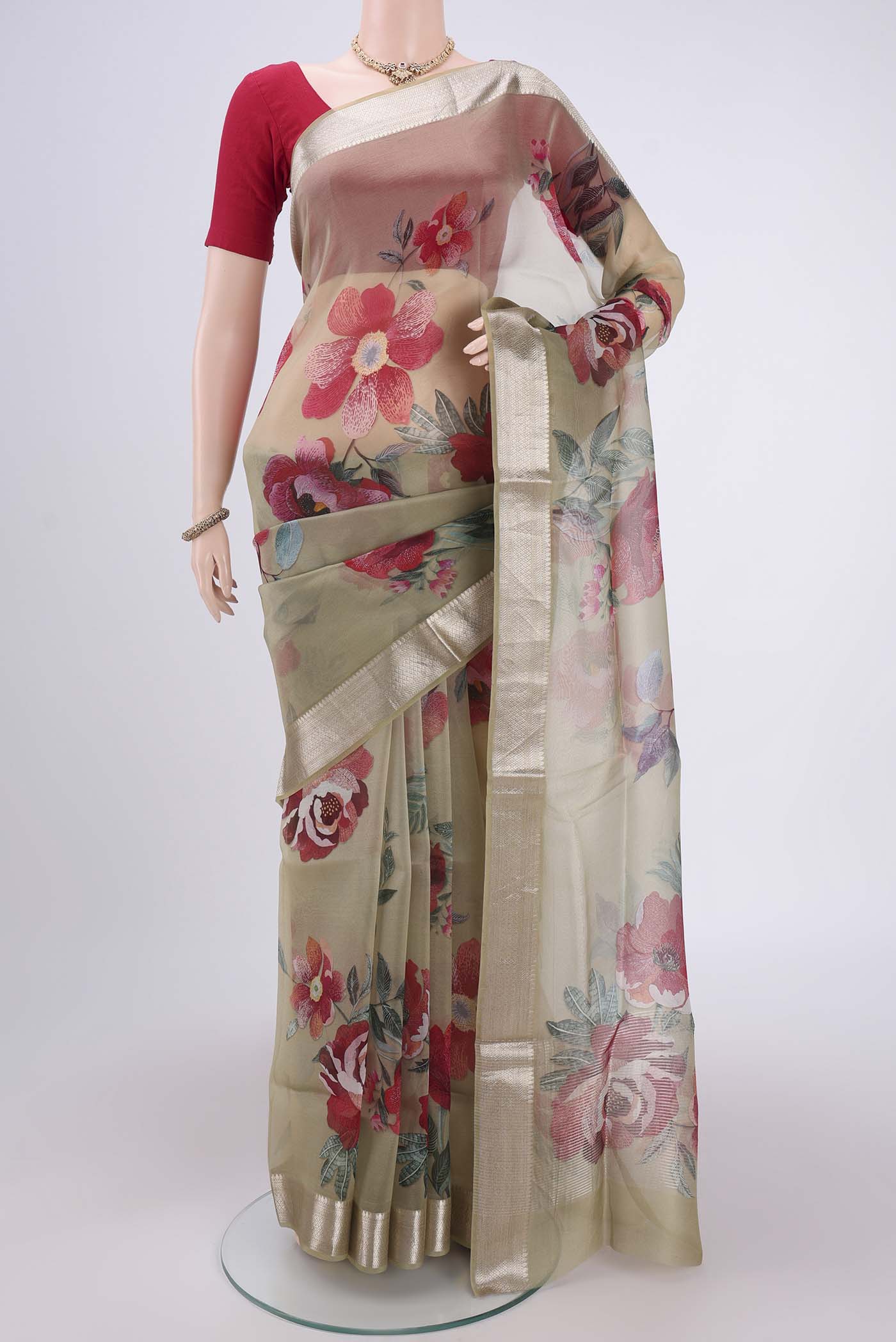 Sage Green Organza Silk Saree with Printed design on the body and Zari Border.  displayed on a mannequin