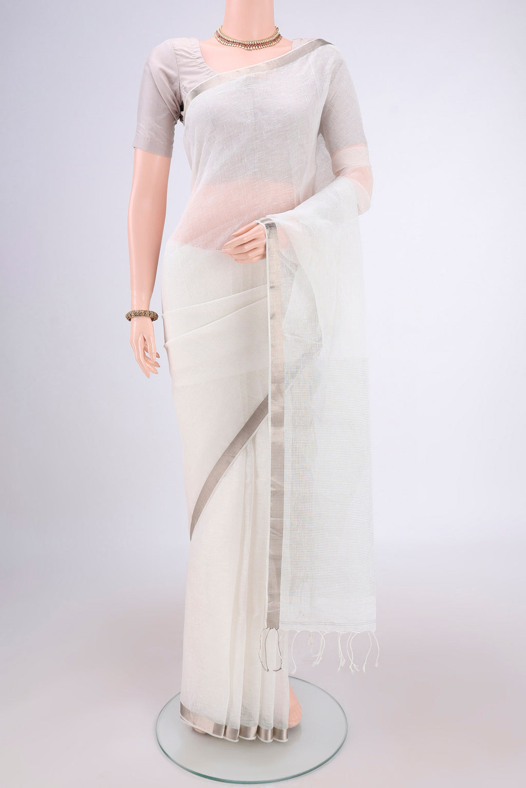 Off White Linen Saree with Plain Body and Zari Border.  displayed on a mannequin