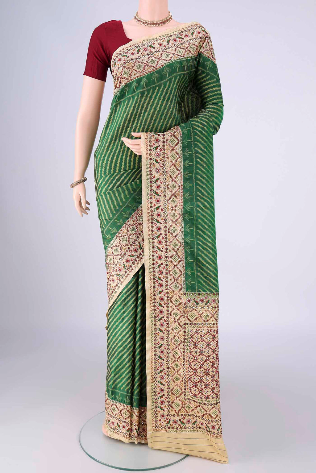 Green Kanchipuram Silk Saree with Pure Ikat on the body and Embroidery Border.  displayed on a mannequin