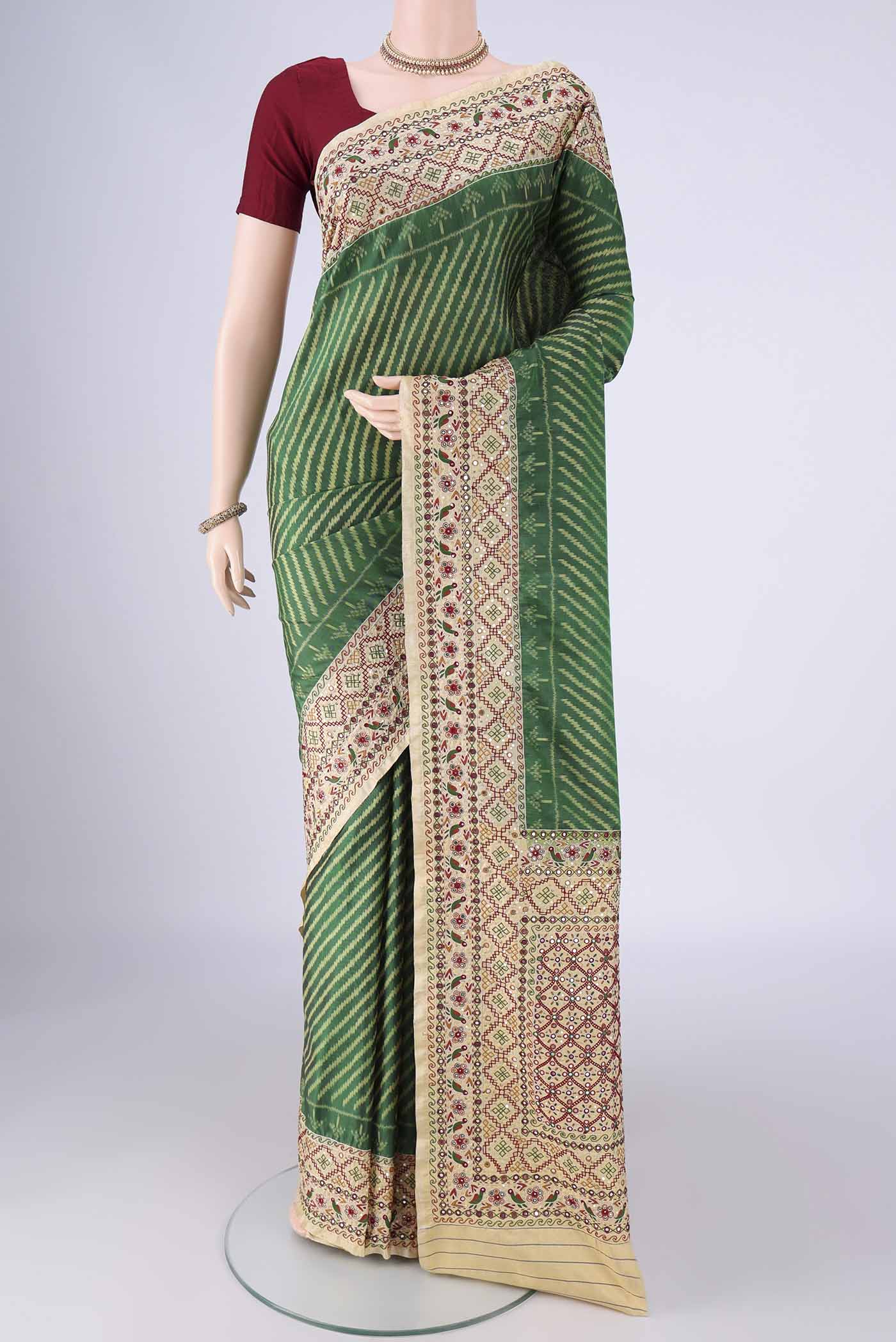 Green Kanchipuram Silk Saree with Pure Ikat on the body and Embroidery Border.  displayed on a mannequin