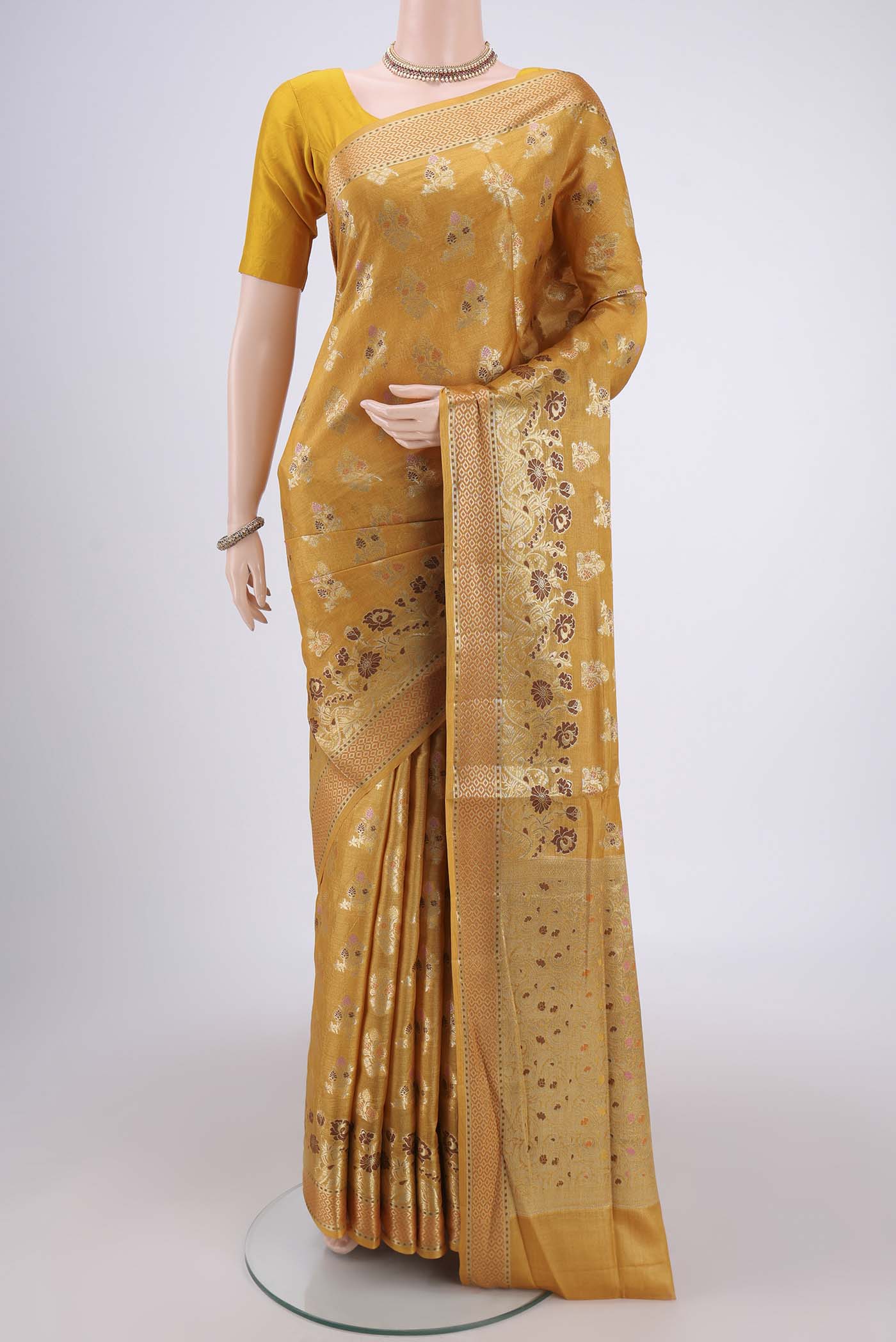 Mustard Banarasi Raw Silk Saree with Zari And Thread Butta on the body and Zari And Thread Border.  displayed on a mannequin