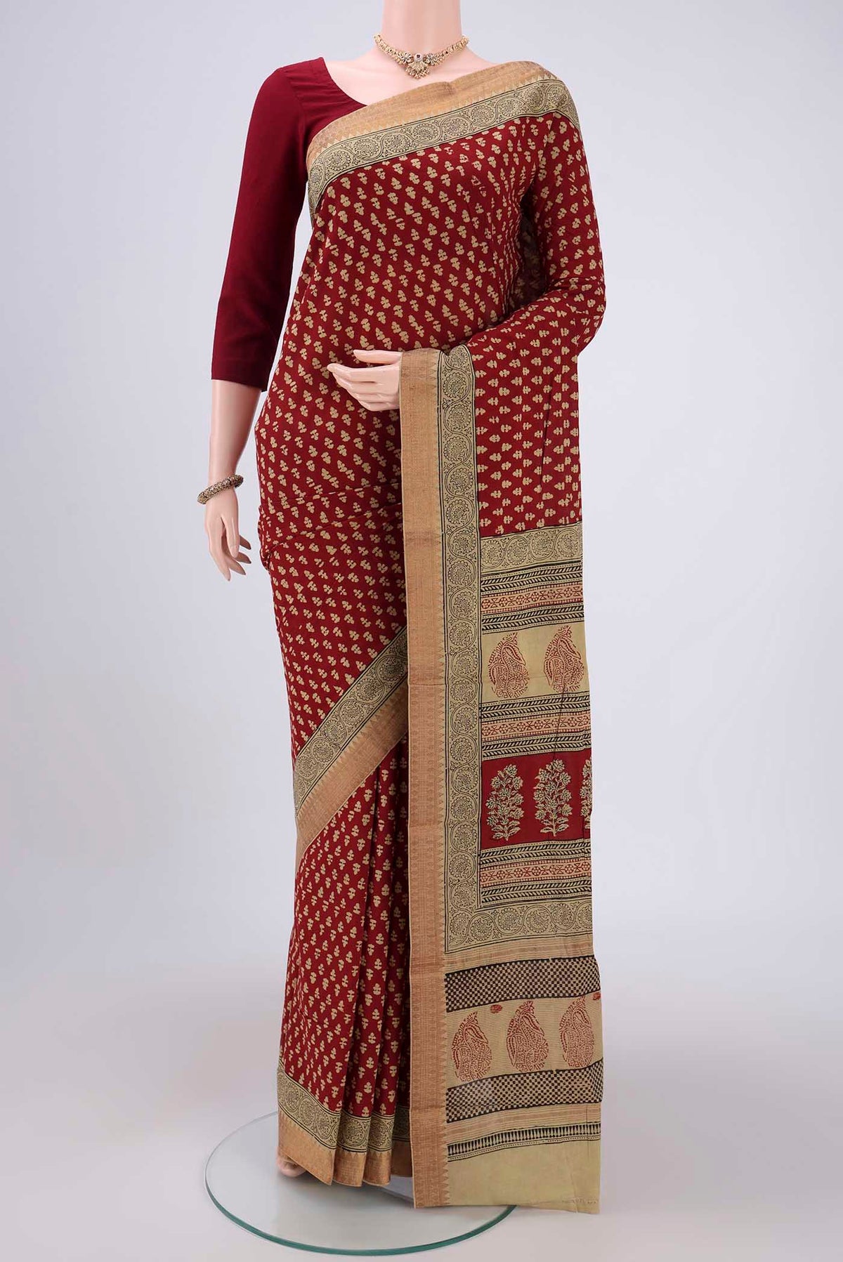 Maroon Maheshwari Silk Cotton Saree with Stripes on the body and Zari Border.  displayed on a mannequin
