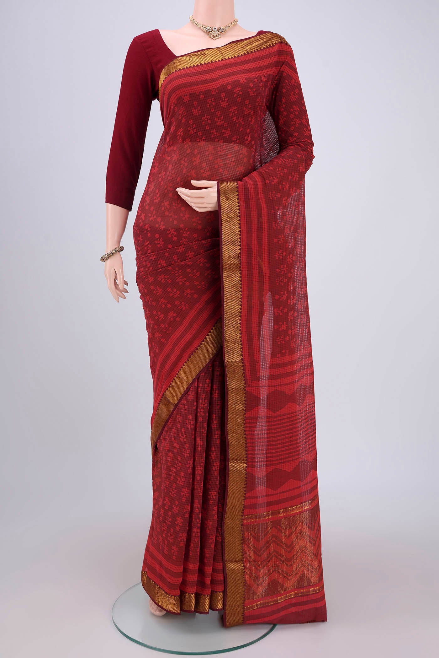 Red Maheshwari Silk Cotton Saree with Batik Print on the body and Zari Border.  displayed on a mannequin