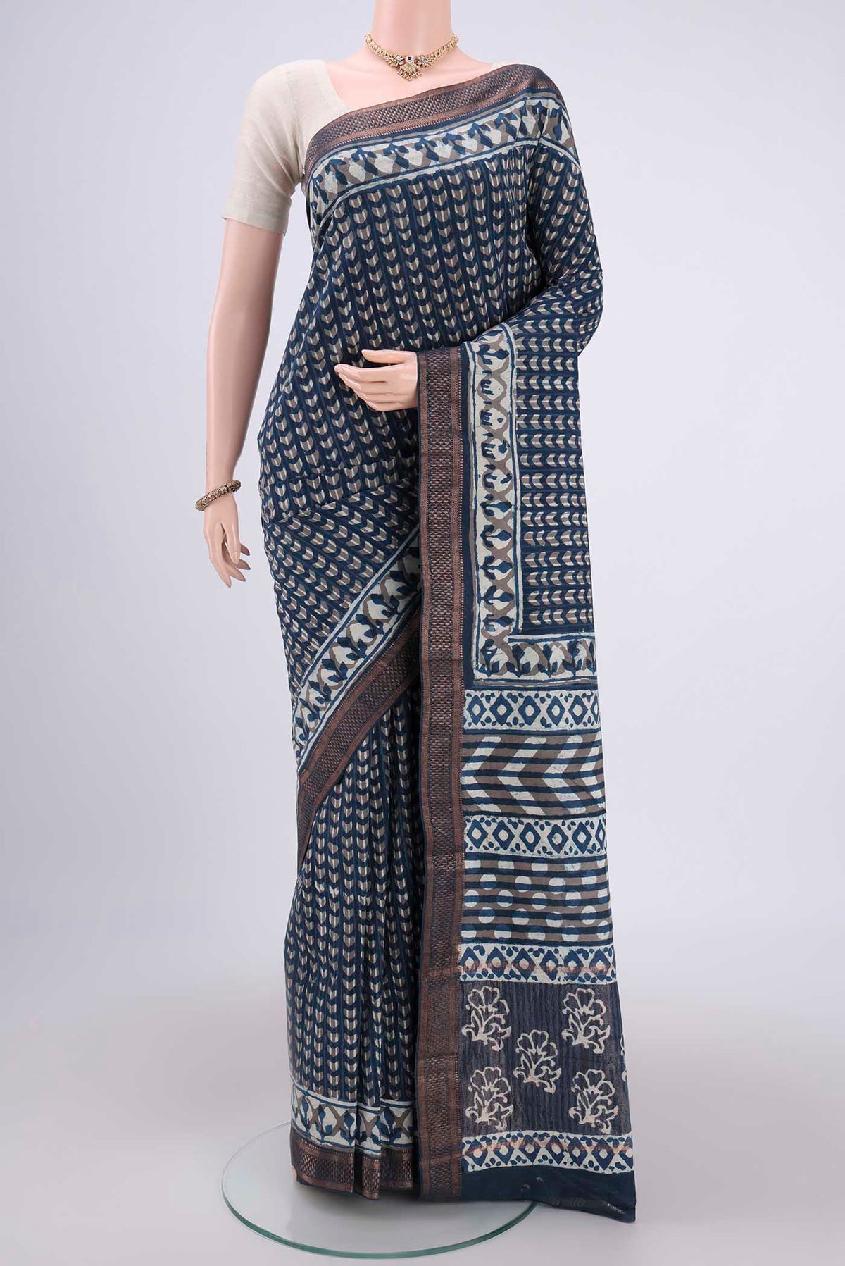 Indigo Maheshwari Silk Cotton Saree with Batik Print on the body and Zari Border.  displayed on a mannequin
