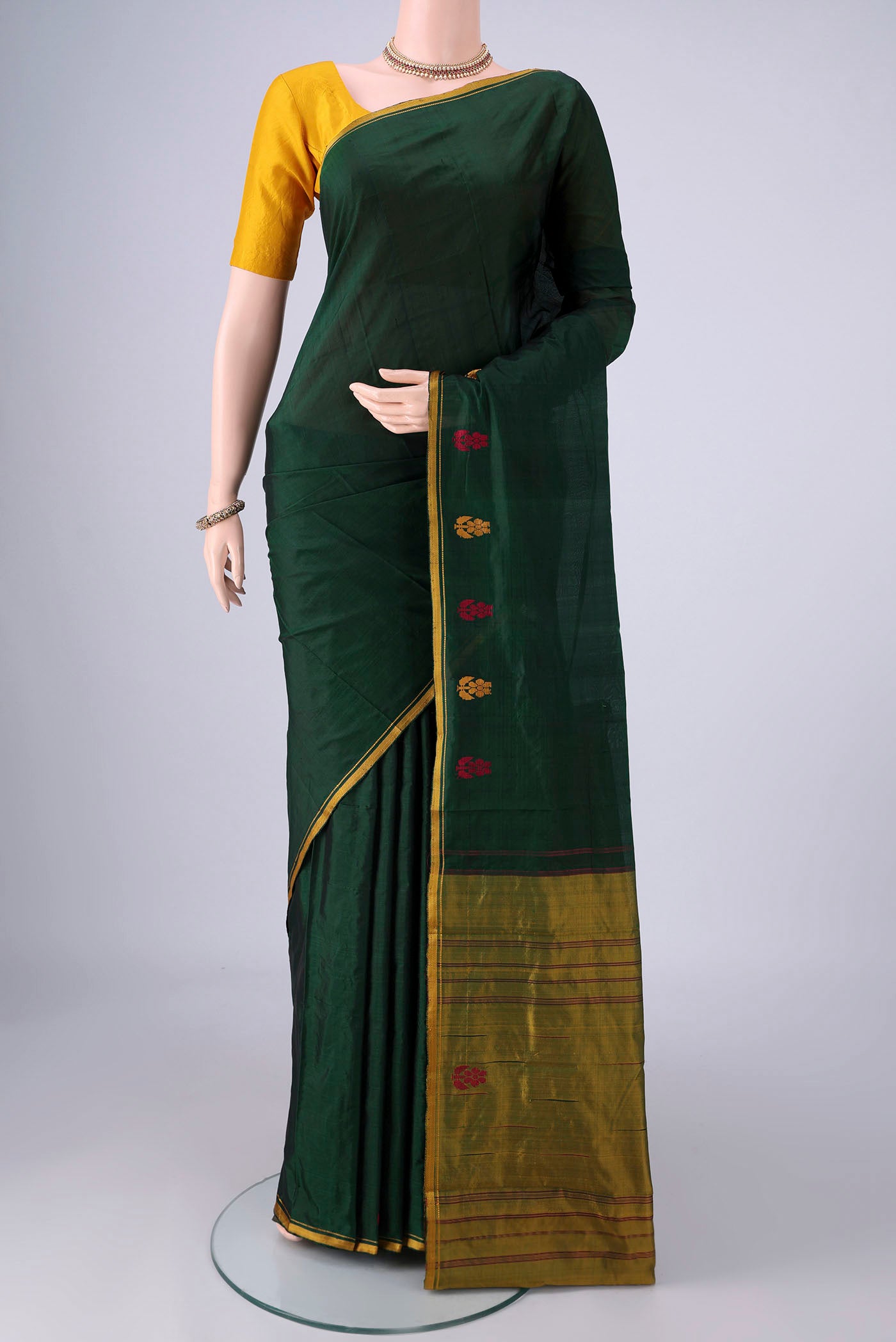 Bottle Green Kanchipuram Silk Saree with Plain Body and Thread Border.  displayed on a mannequin