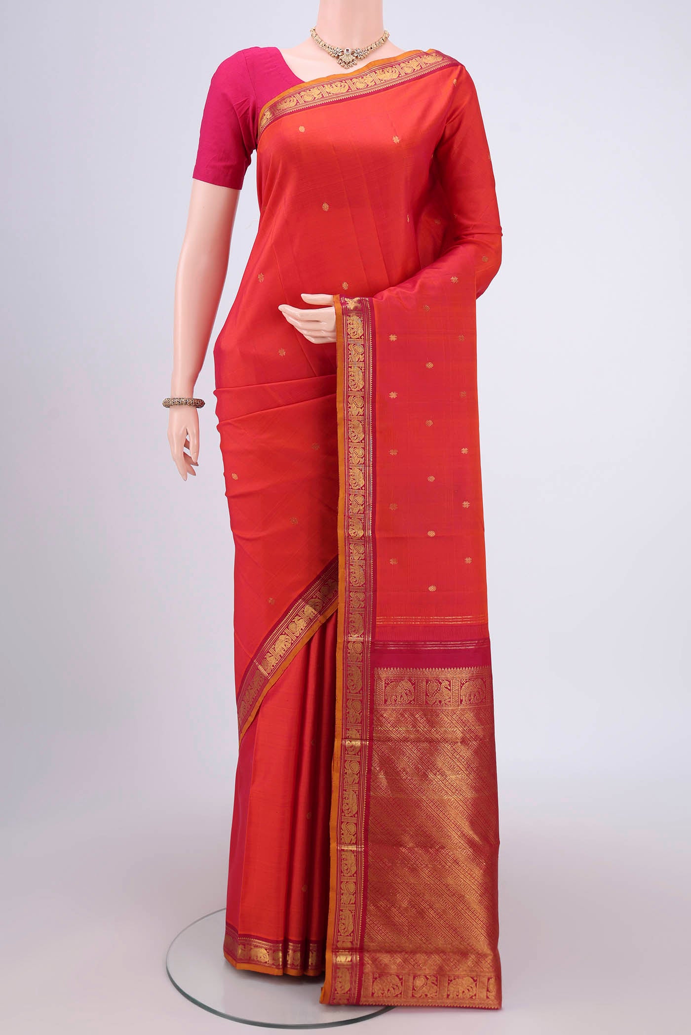Orange Kanchipuram Silk Saree with Plain Body and Zari Border.  displayed on a mannequin