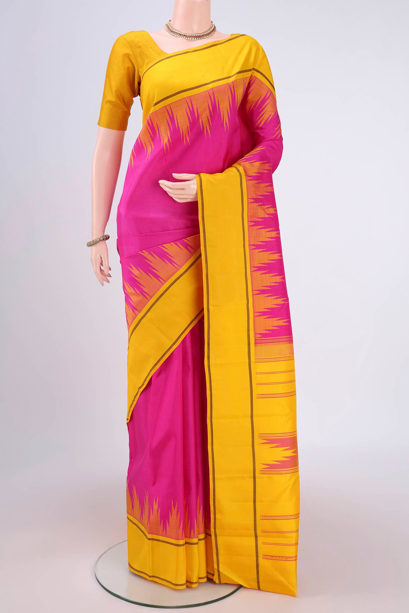 Rani Pink Kanjivaram Saree with Plain Body and Temple Border.  displayed on a mannequin