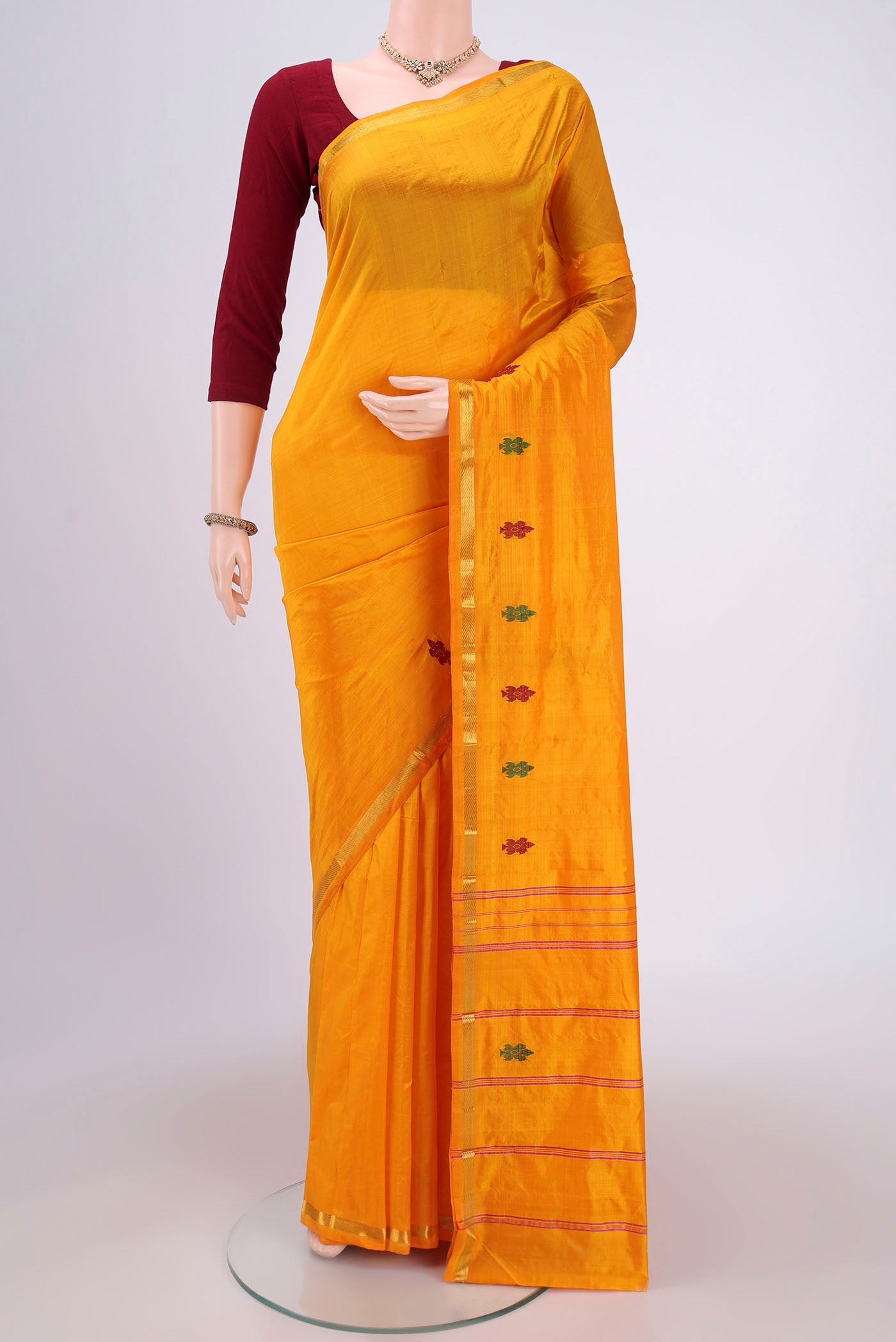 Mustard Kanchipuram Silk Saree with Plain Body and Thread Border.  displayed on a mannequin