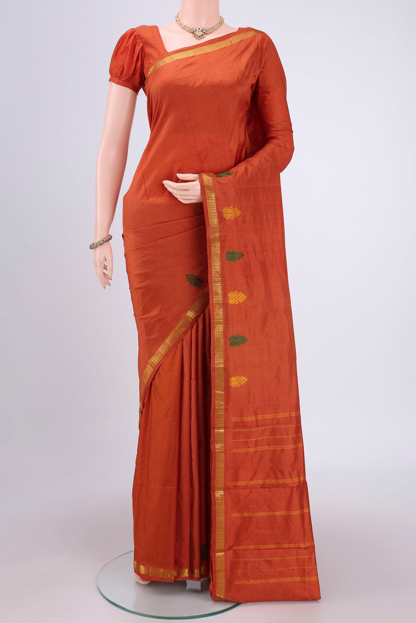 Rust Kanchipuram Silk Saree with Plain Body and Thread Border.  displayed on a mannequin