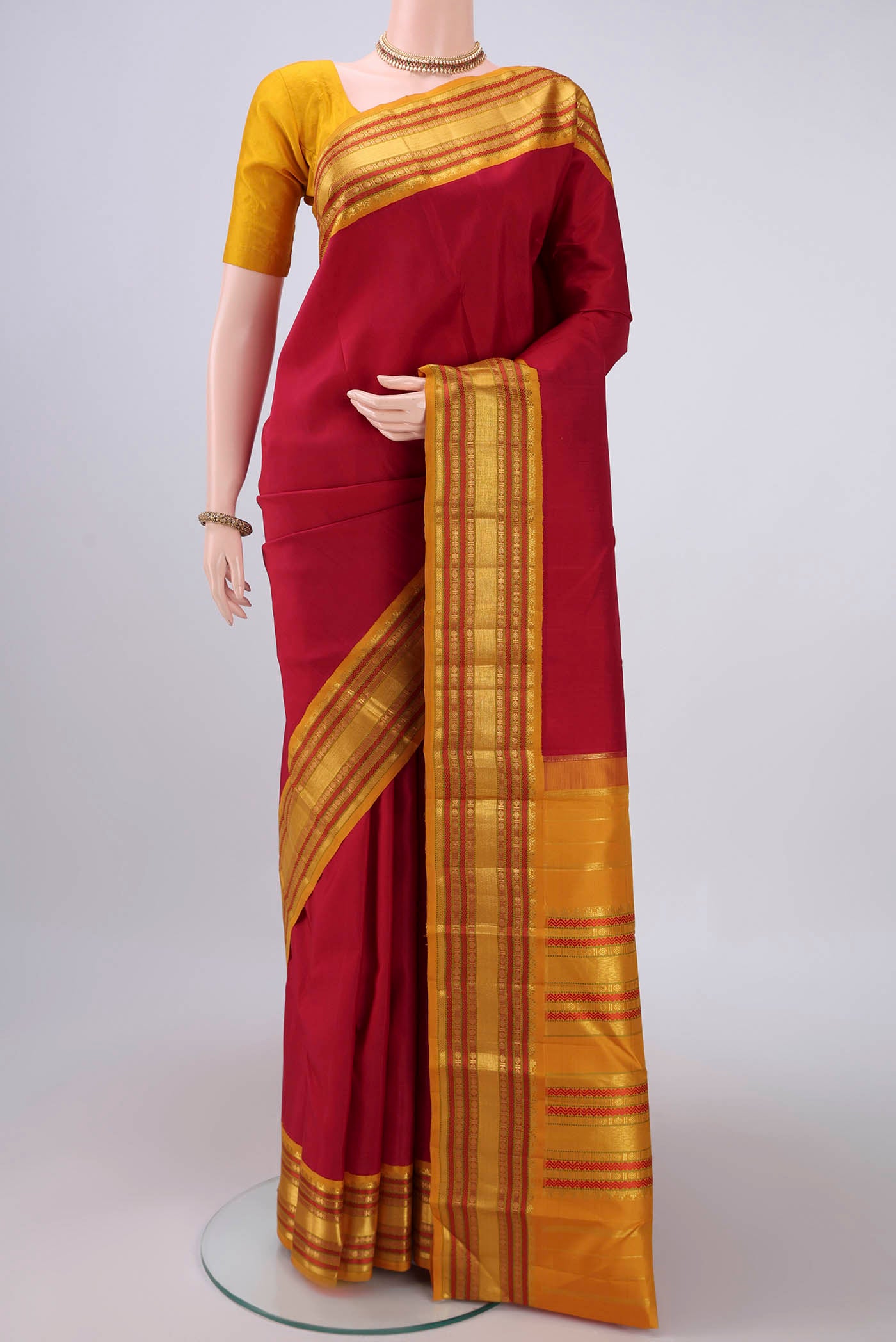 Pure Silk Pure Zari Maroon Kanjivaram Saree with Plain Body and Zari Border.  displayed on a mannequin