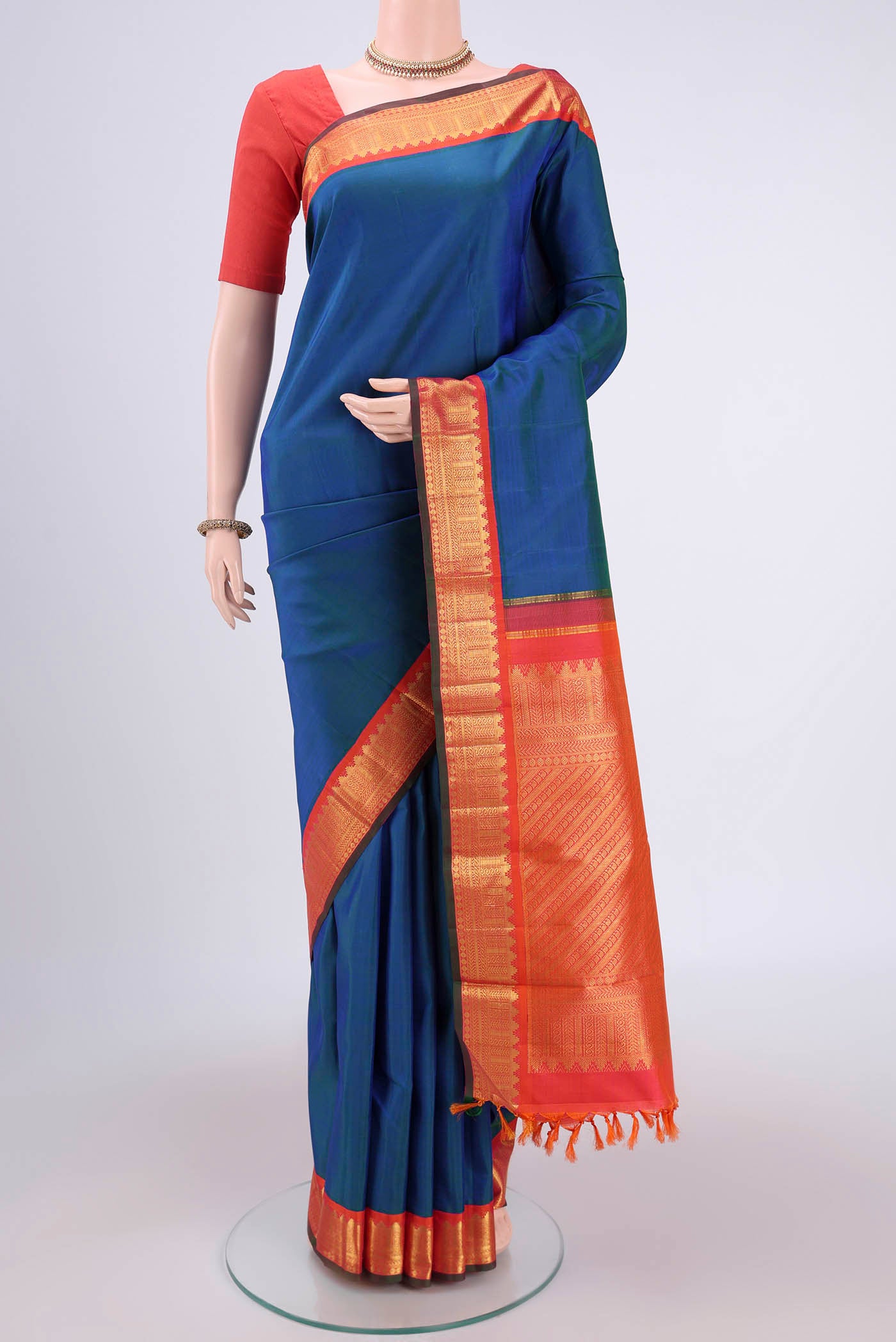 Pure Silk Pure Zari Peacock Blue Kanjivaram Saree with Plain Body and Zari Border.  displayed on a mannequin