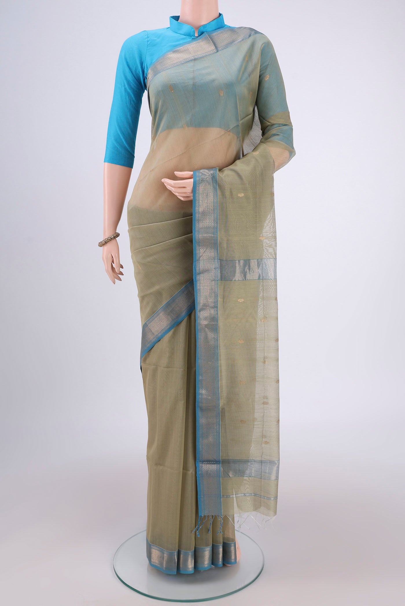 Sage Green Maheshwari Silk Cotton Saree with Zari Butta on the body and Zari Border.  displayed on a mannequin