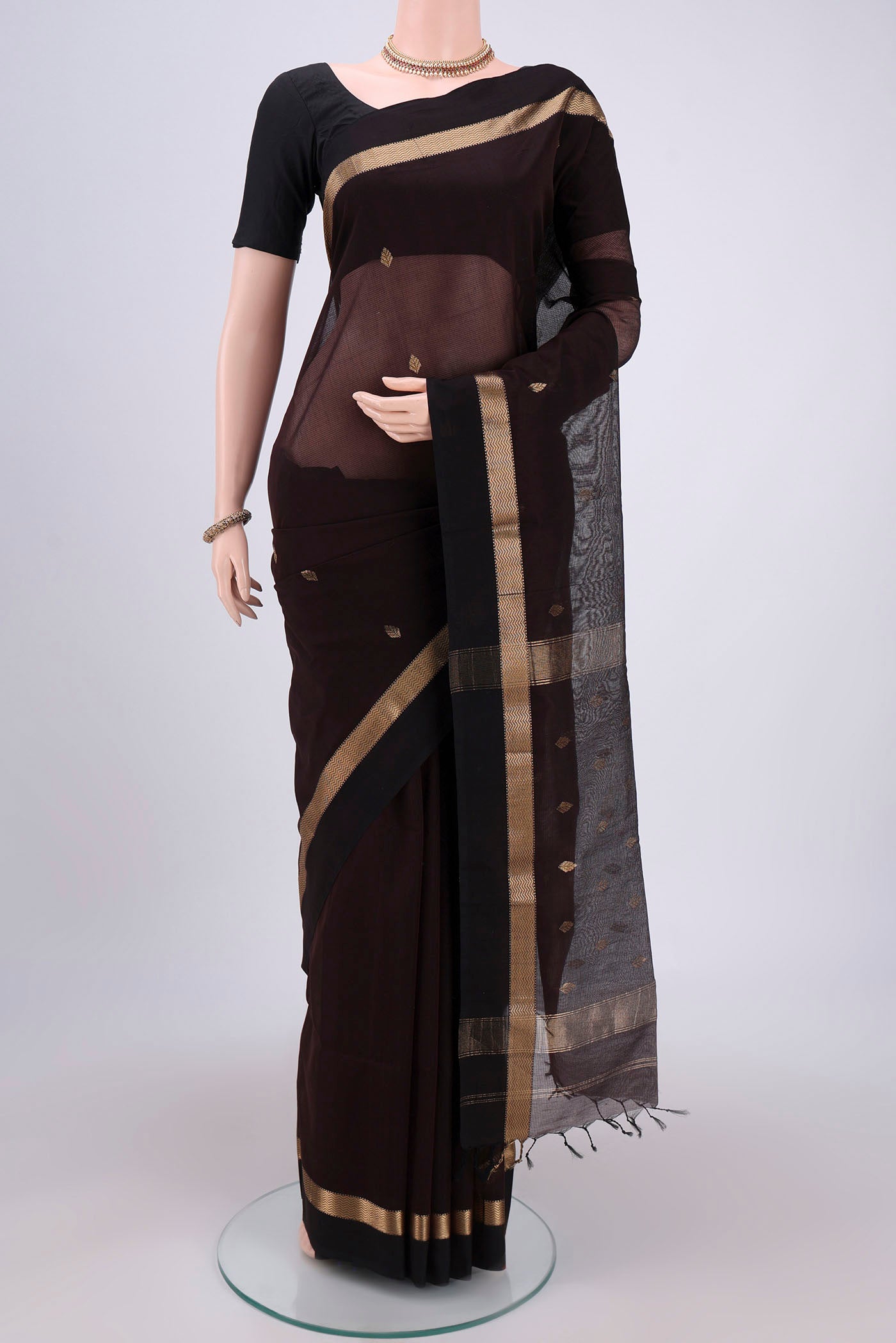 Brown Maheshwari Silk Cotton Saree with Zari Butta on the body and Zari Border.  displayed on a mannequin