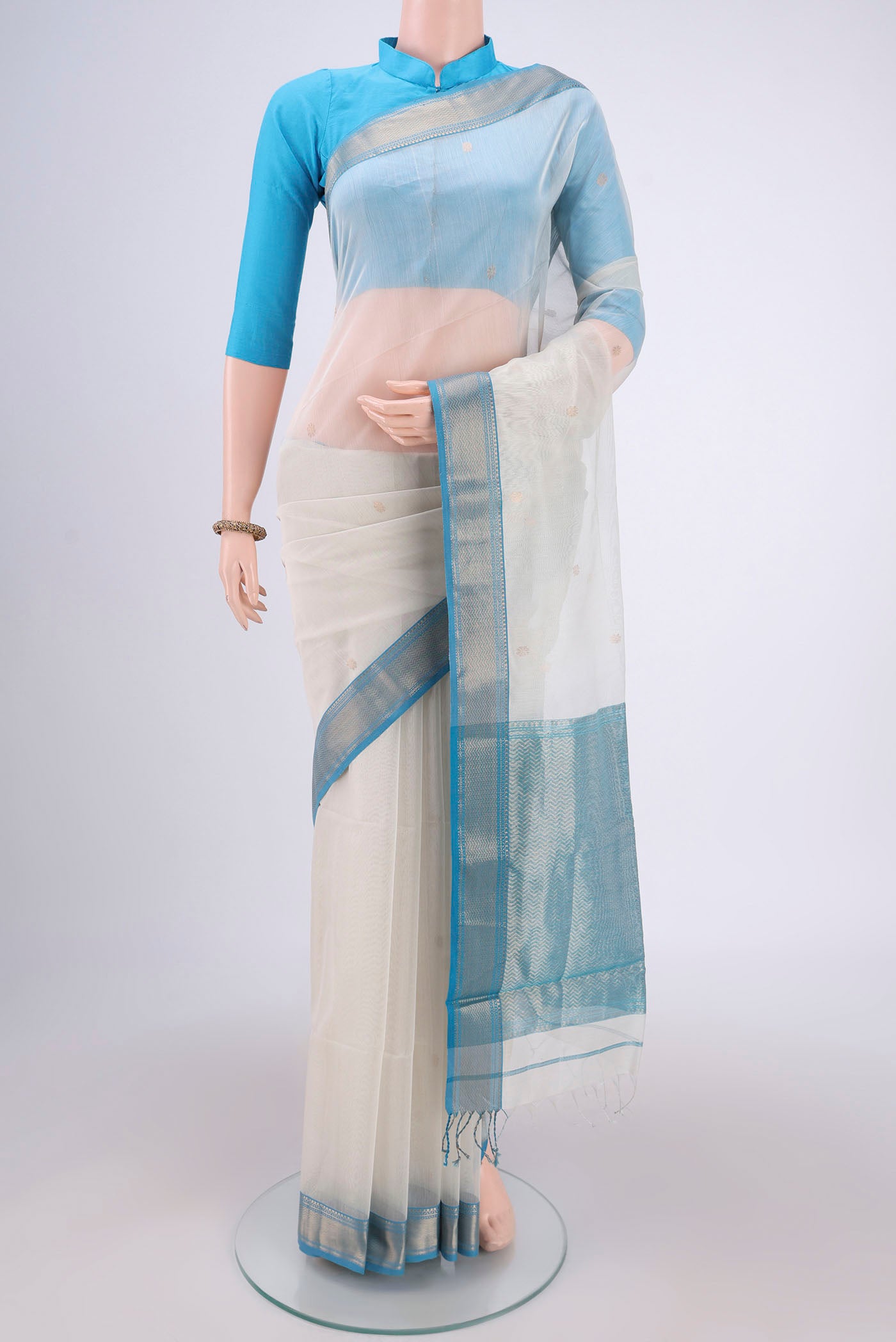 Off White Maheshwari Silk Cotton Saree with Zari Butta on the body and Zari Border.  displayed on a mannequin