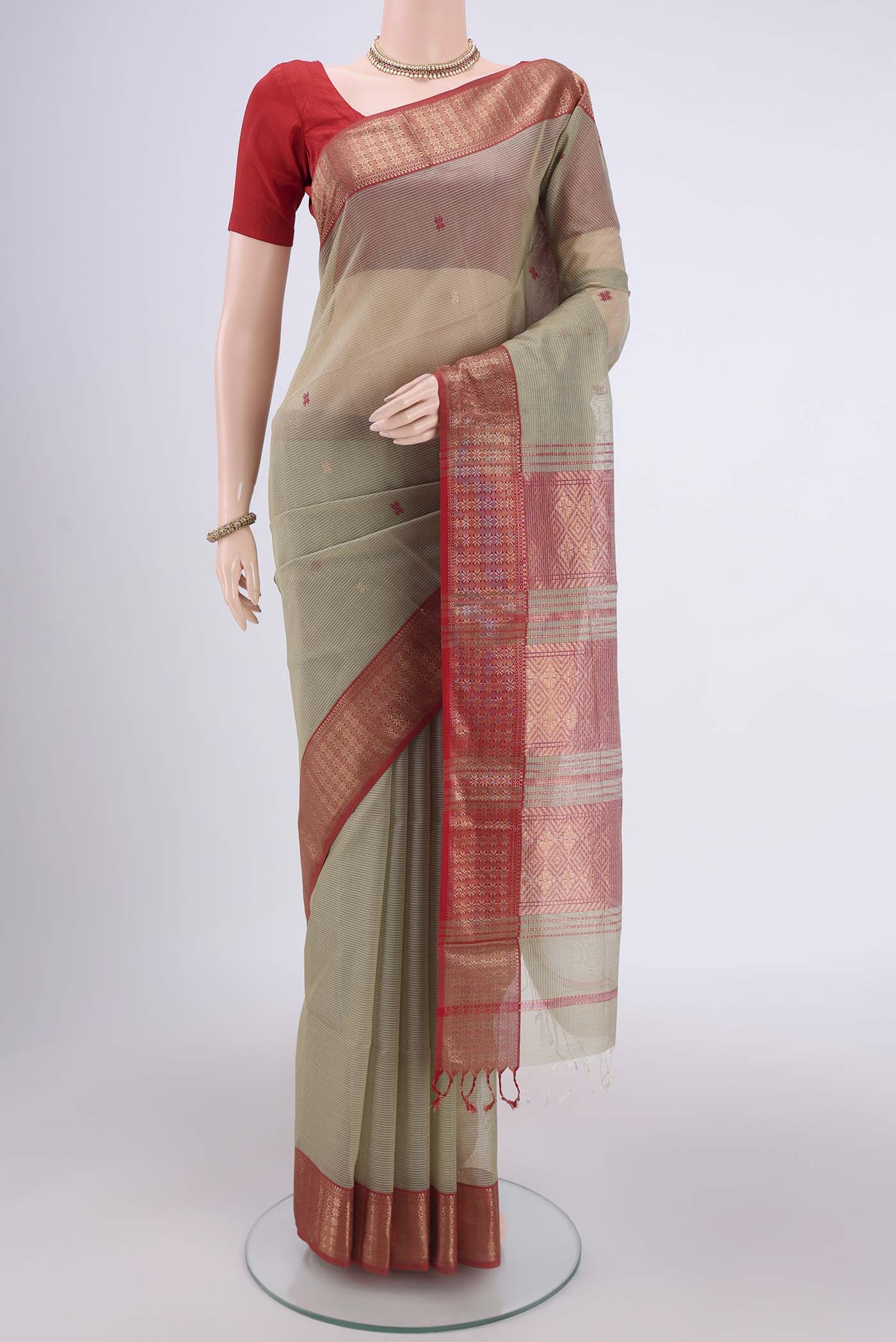 Pista Green Maheshwari Silk Cotton Saree with Zari And Thread Butta on the body and Zari Border.  displayed on a mannequin